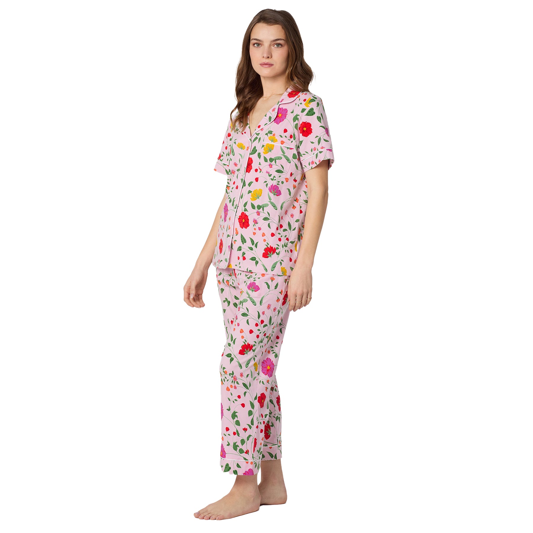 Side view of pink cotton pajama set featuring bright floral print, contrast piping and relaxed cropped pant silhouette.
