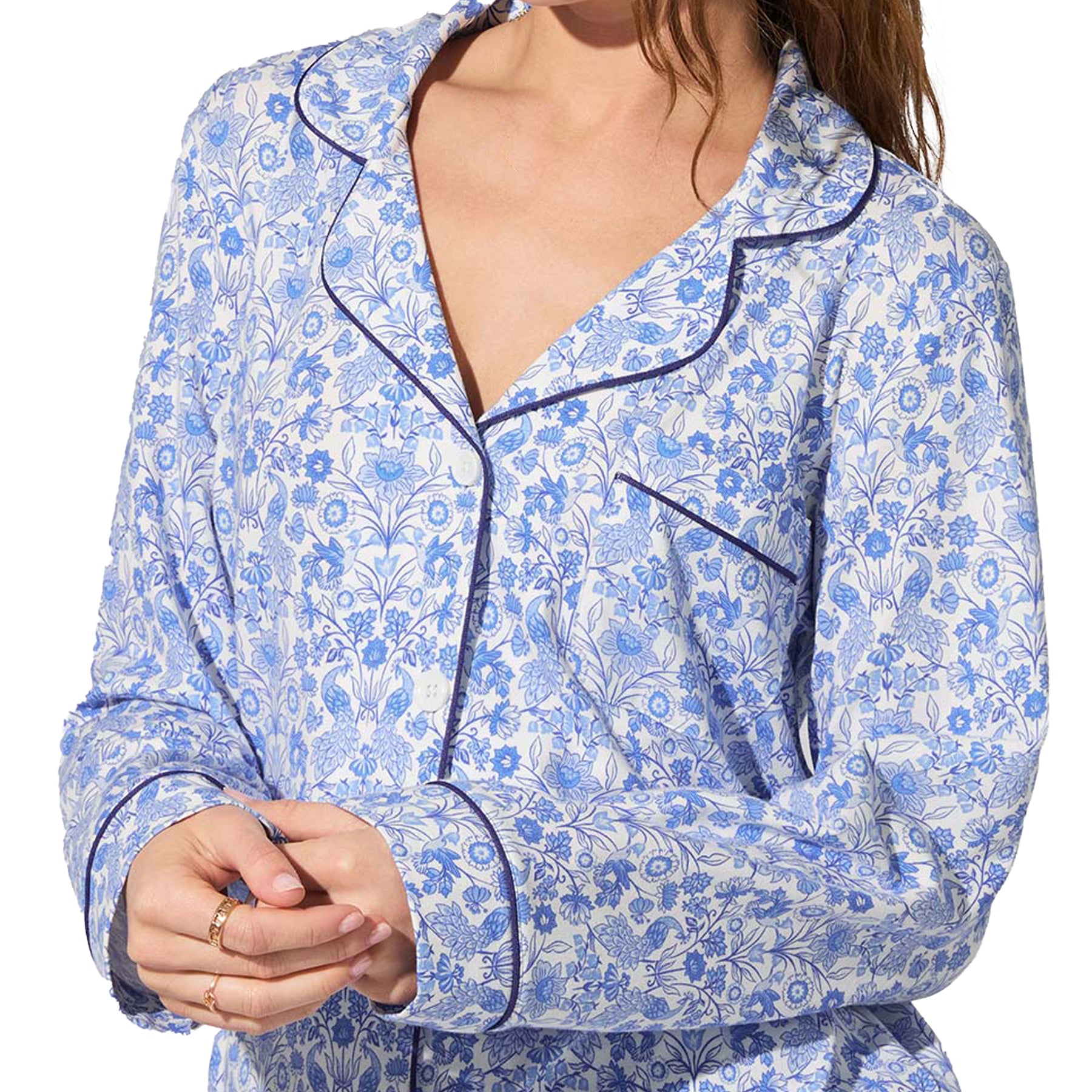 Close-up of white pyjama shirt with blue floral design and navy piping on collar and pocket.