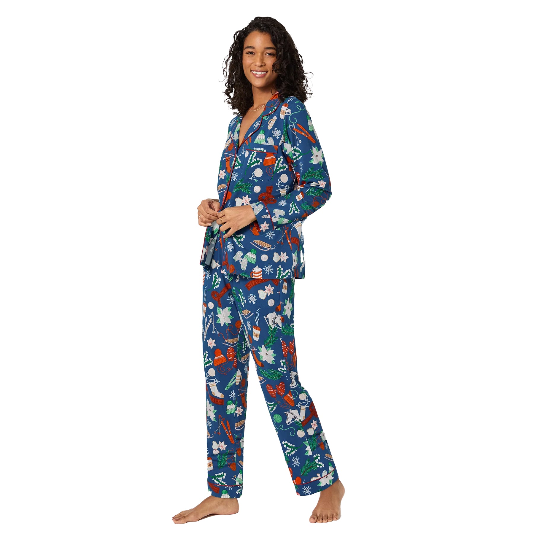 Side view of woman in navy Christmas-themed pyjama set with colourful holiday illustrations.