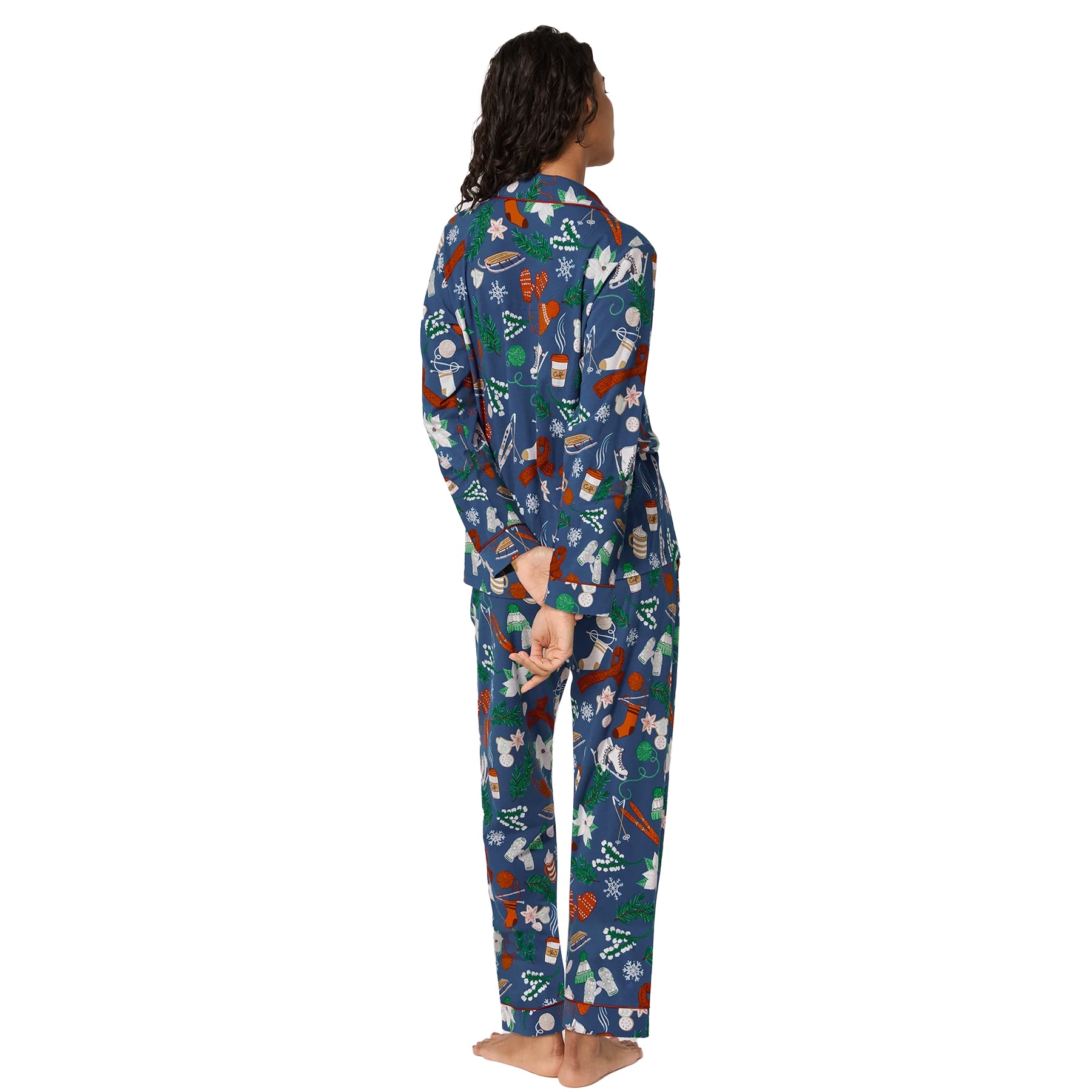 Back view of women’s navy cotton pyjama set decorated with red, white, and green holiday patterns.