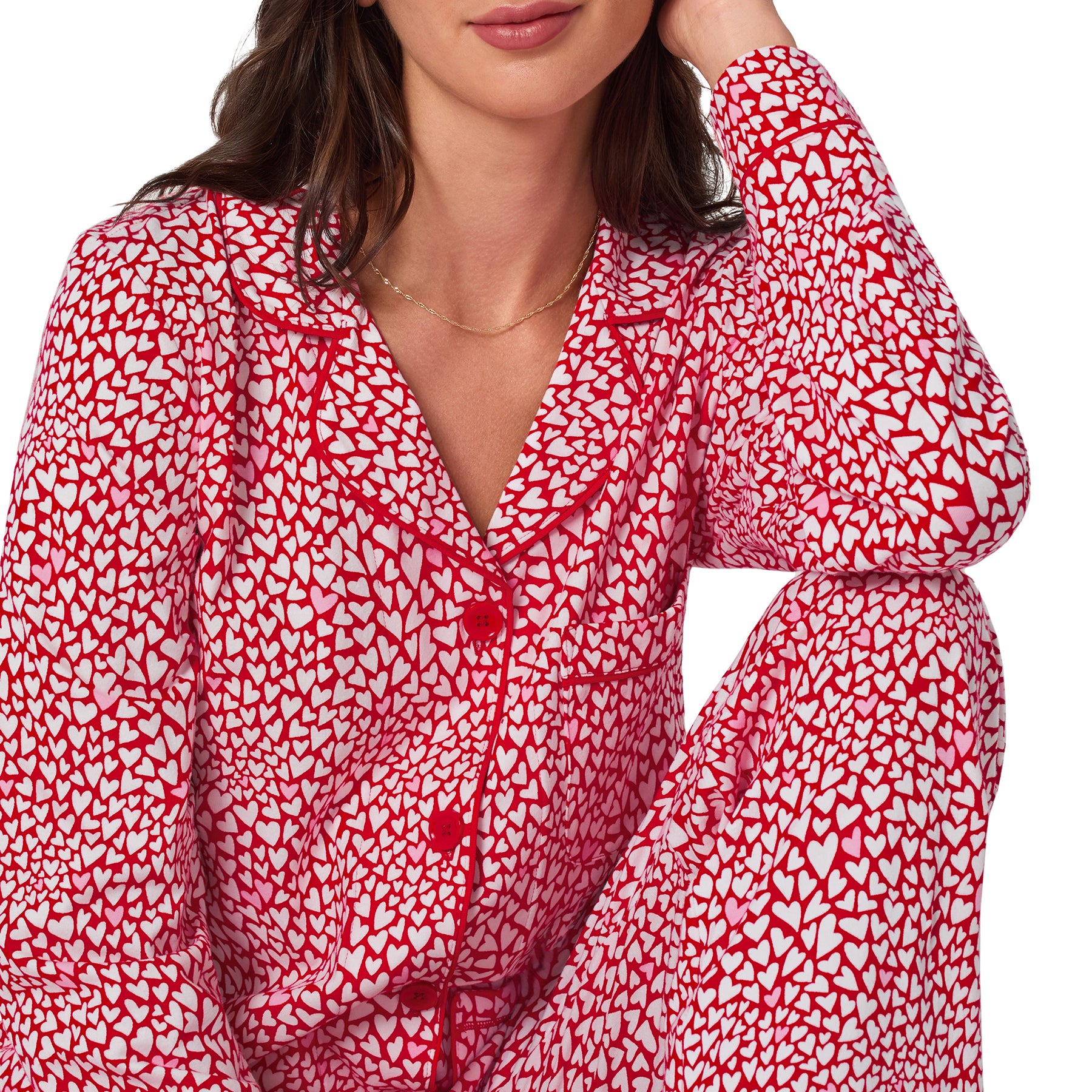 Red and white patterned blouse worn by a person on a white background