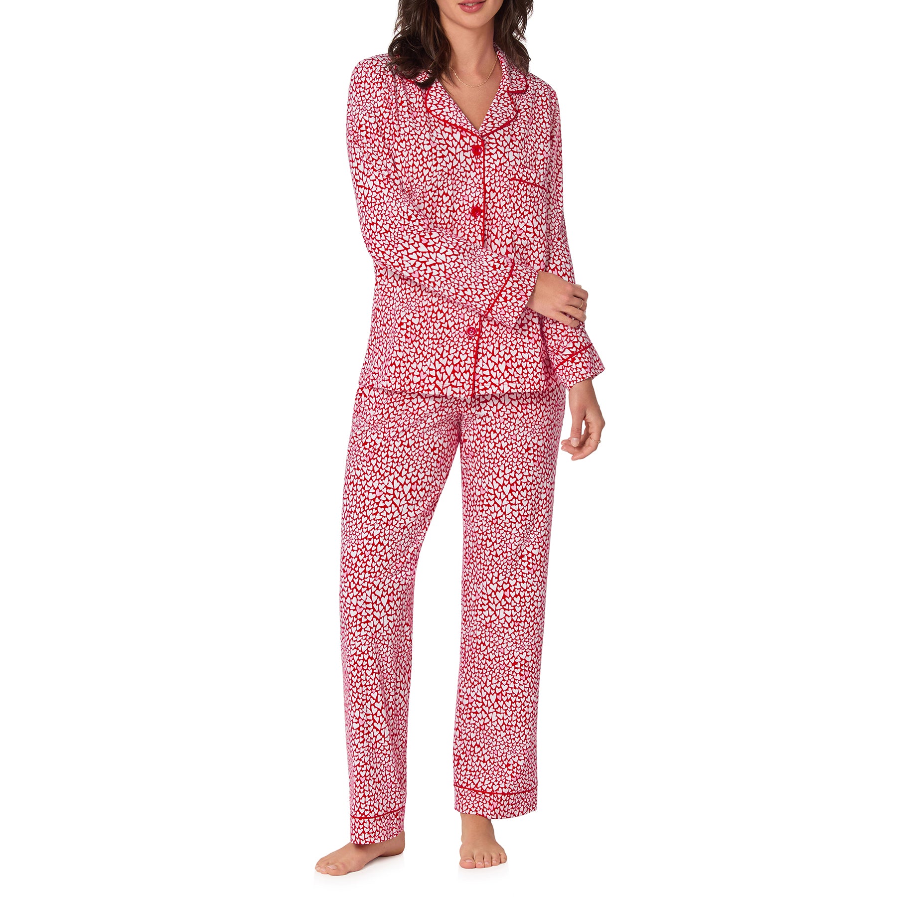 Woman wearing a red and white patterned pajama set on a white background