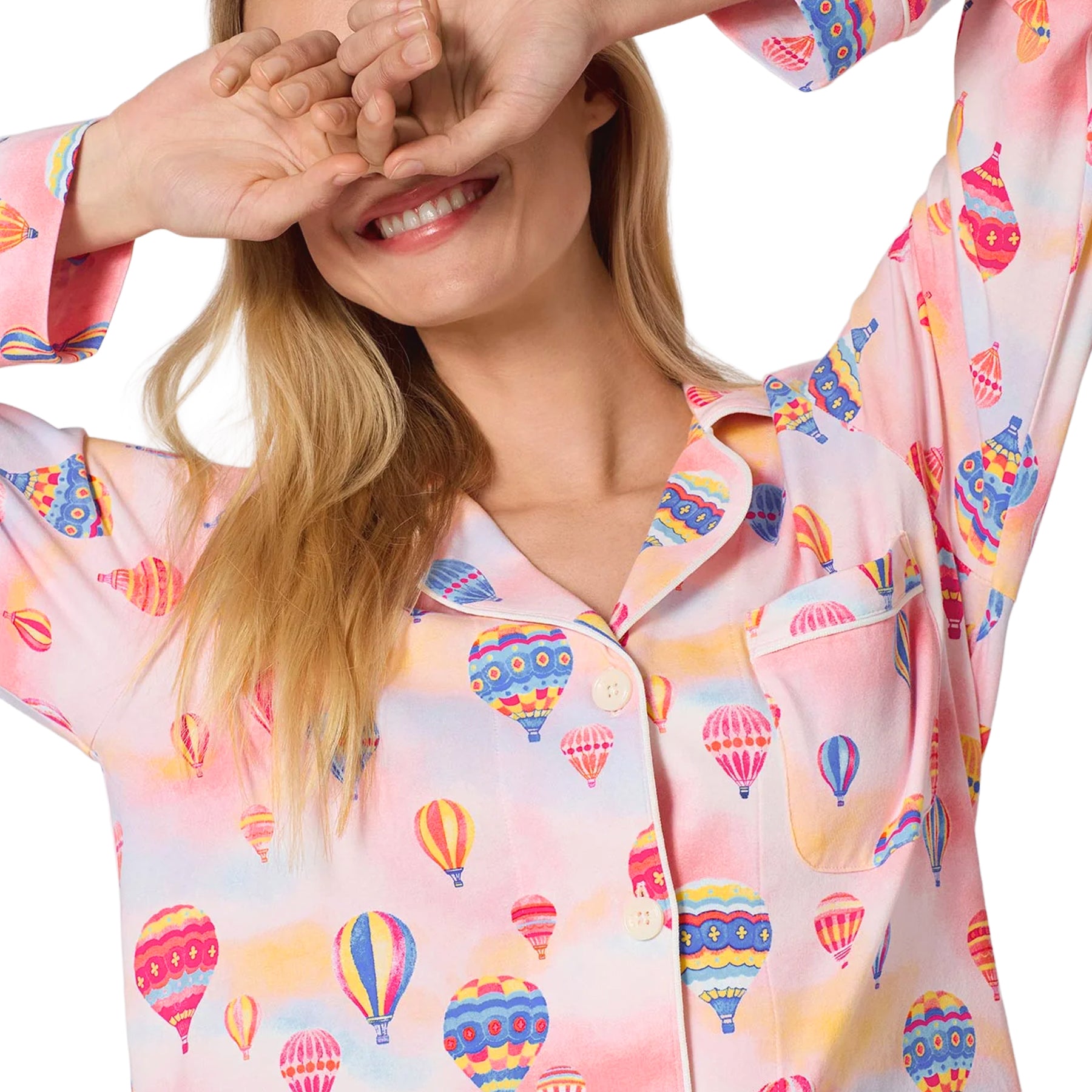 Close-up of a pink button-front pajama top featuring colourful hot air balloons, notched collar, chest pocket and contrast piping.