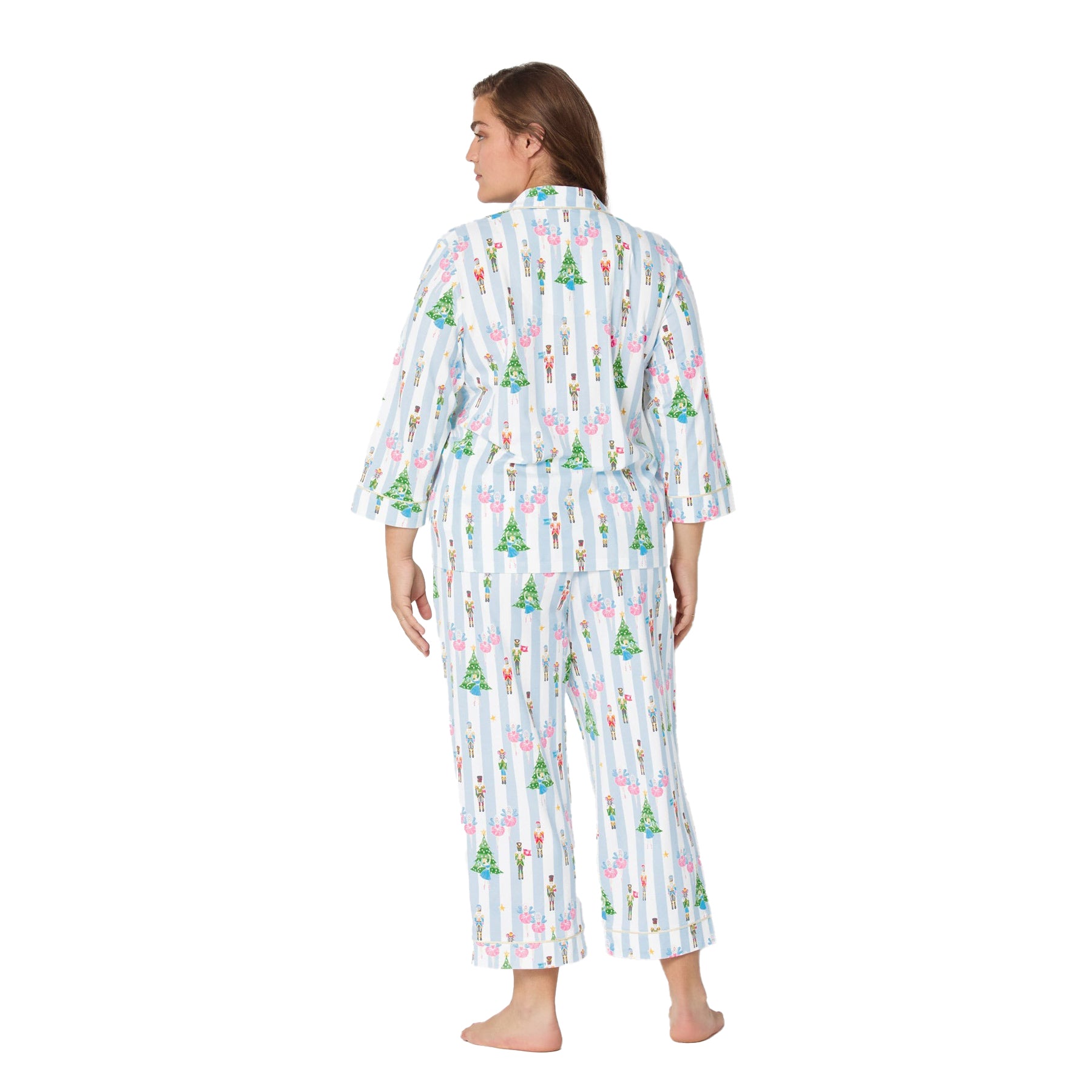 Woman wearing a festive pajama set with a white background