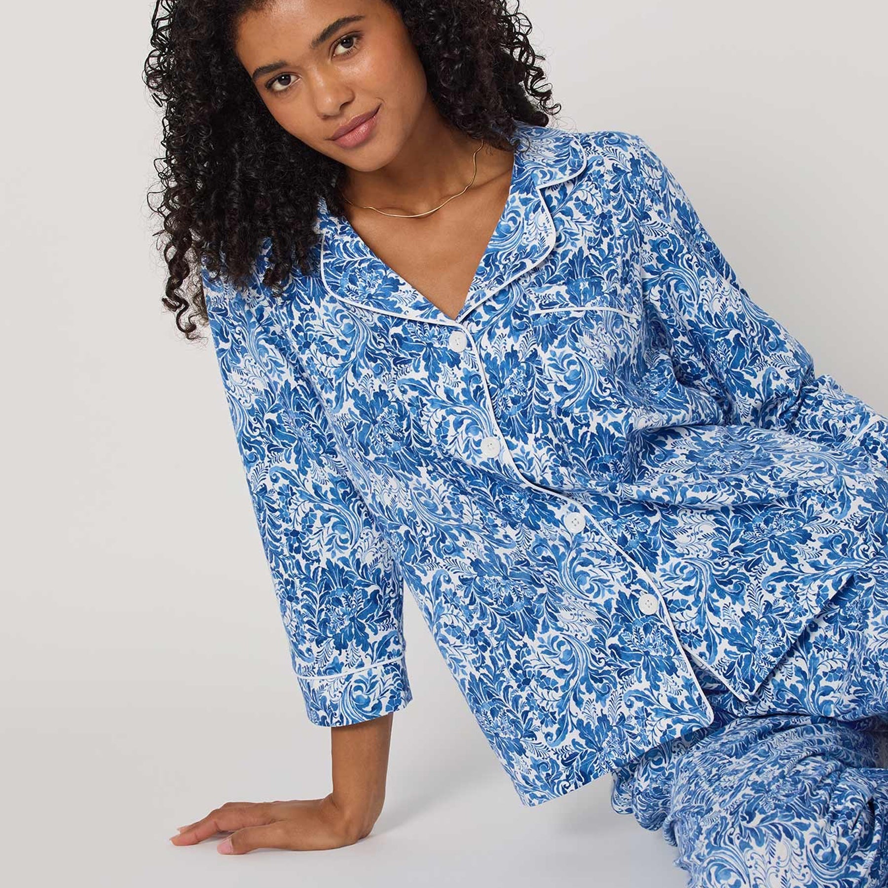 Woman wearing blue floral pajamas on a white background
