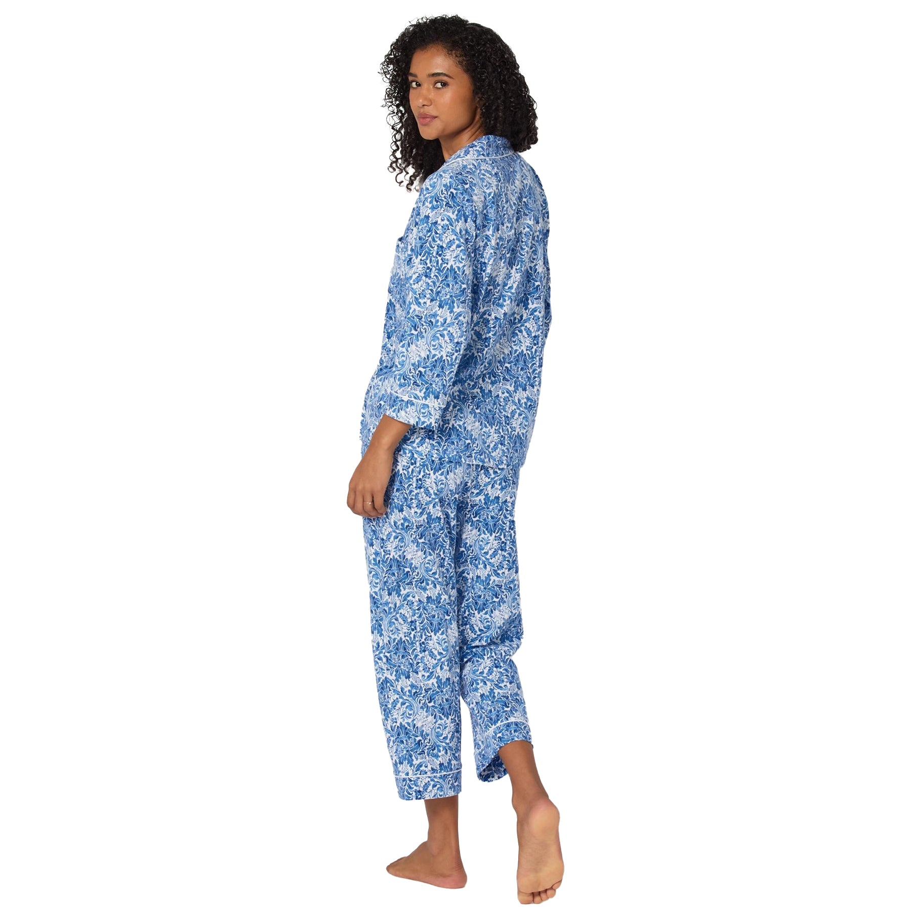 Woman wearing a blue floral pajama set on a white background