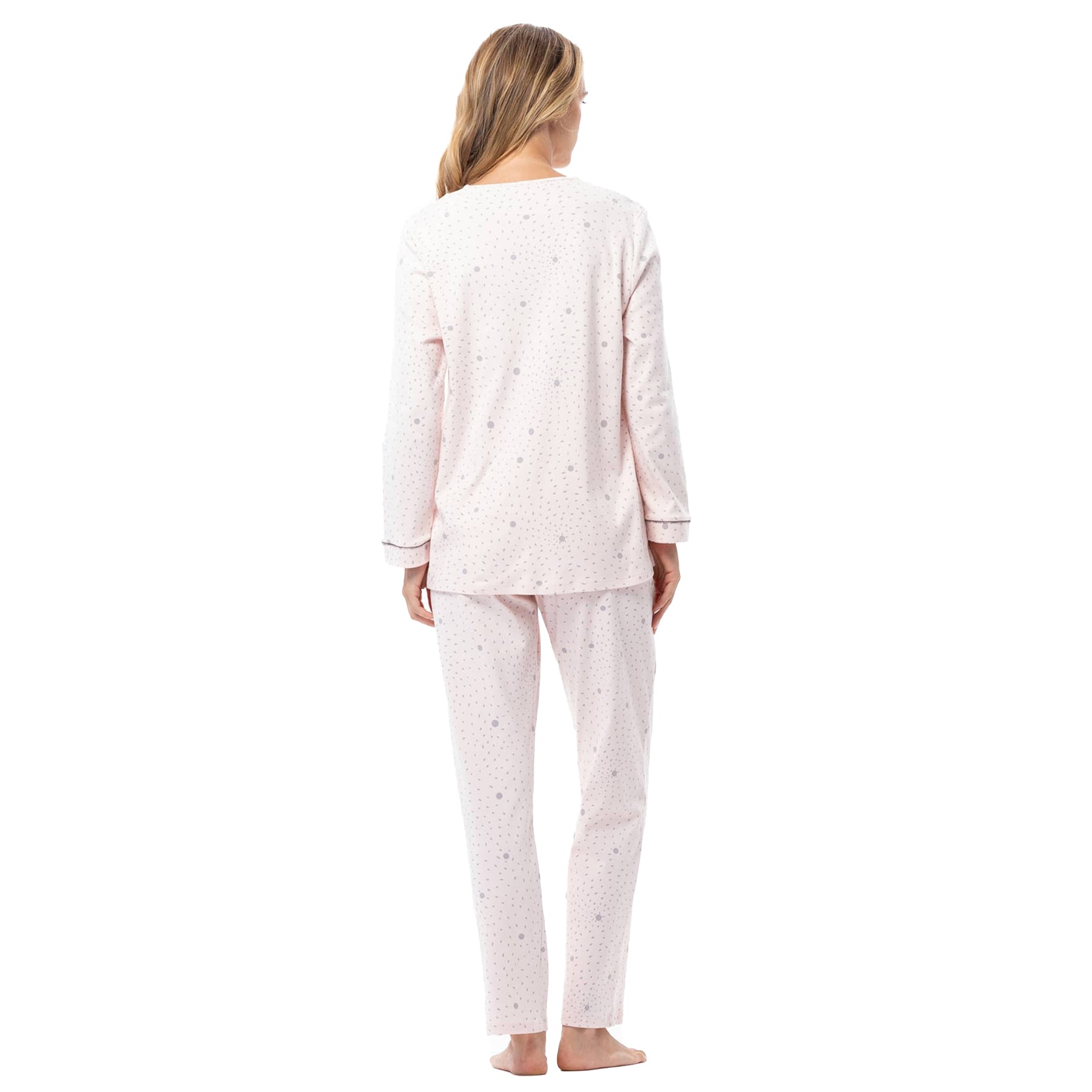 Woman wearing a light pink pajama set with a subtle pattern on a white background