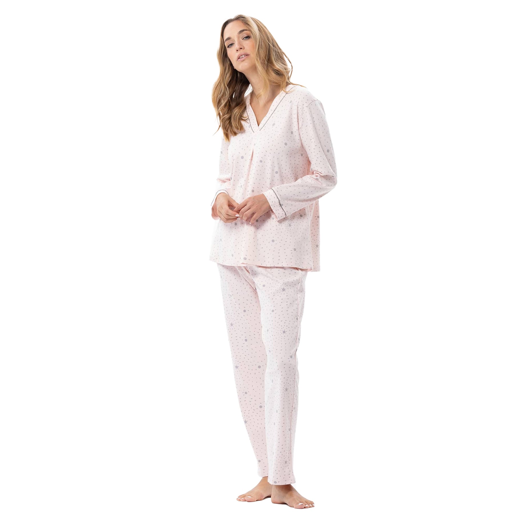 Woman wearing a light pink pajama set with a subtle pattern on a white background