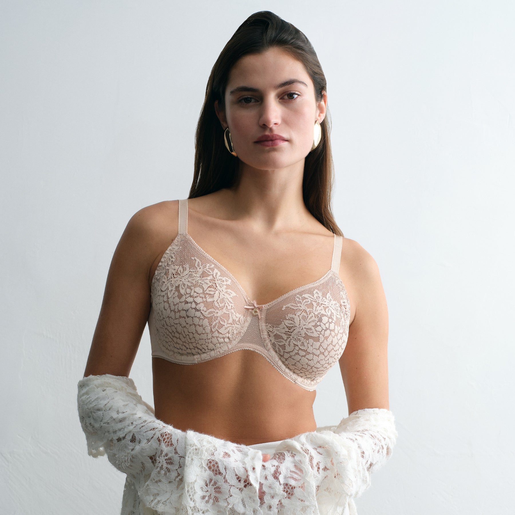 Model wearing Chantelle lace full coverage bra in peau rosée, styled with lace wrap, natural lighting.
