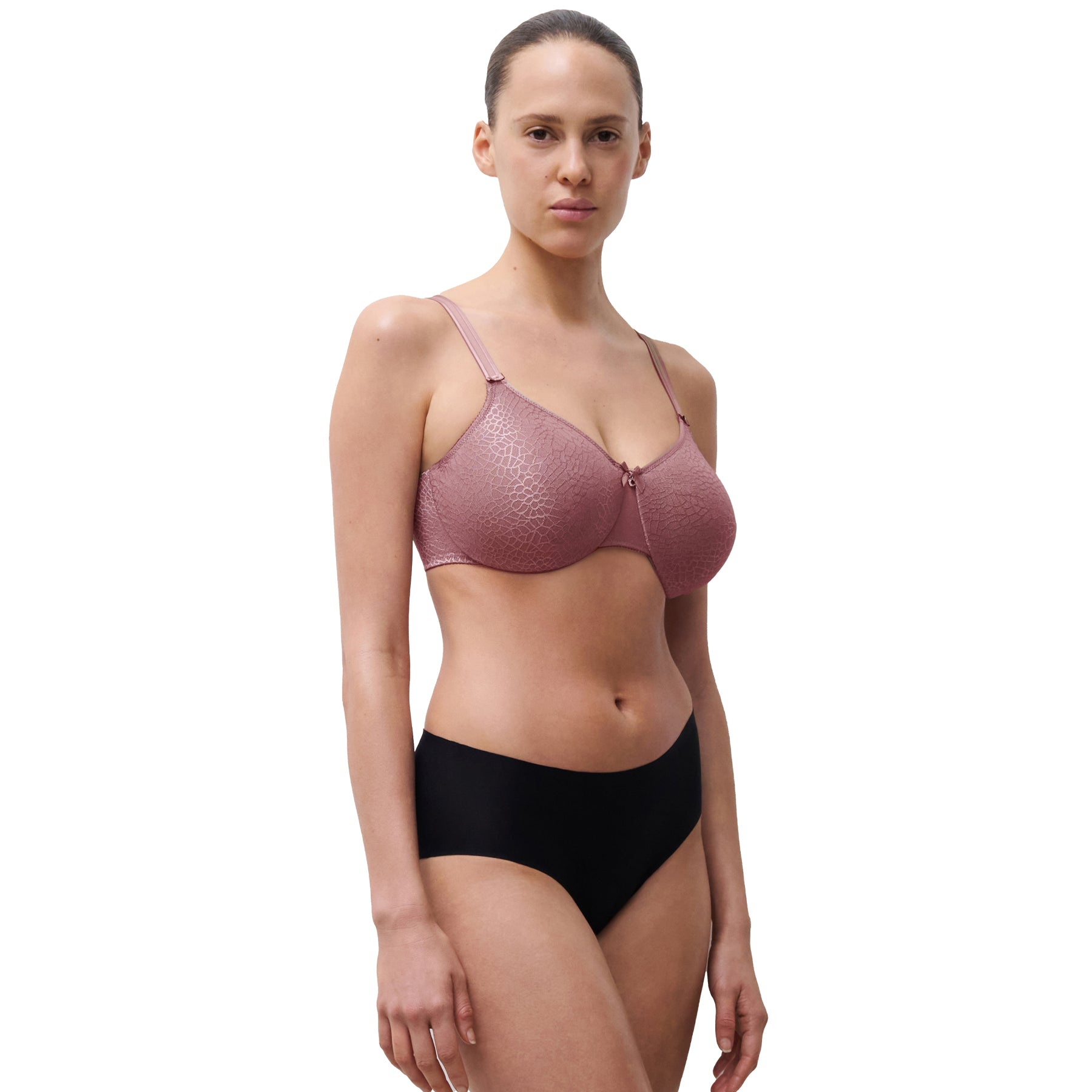 Woman wearing a pink textured bra and black underwear on a white background