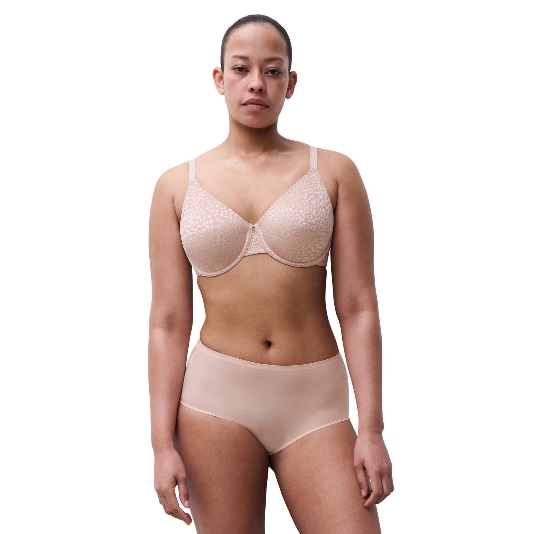 Woman standing in full coverage soft pink minimizer bra and seamless high-rise brief.