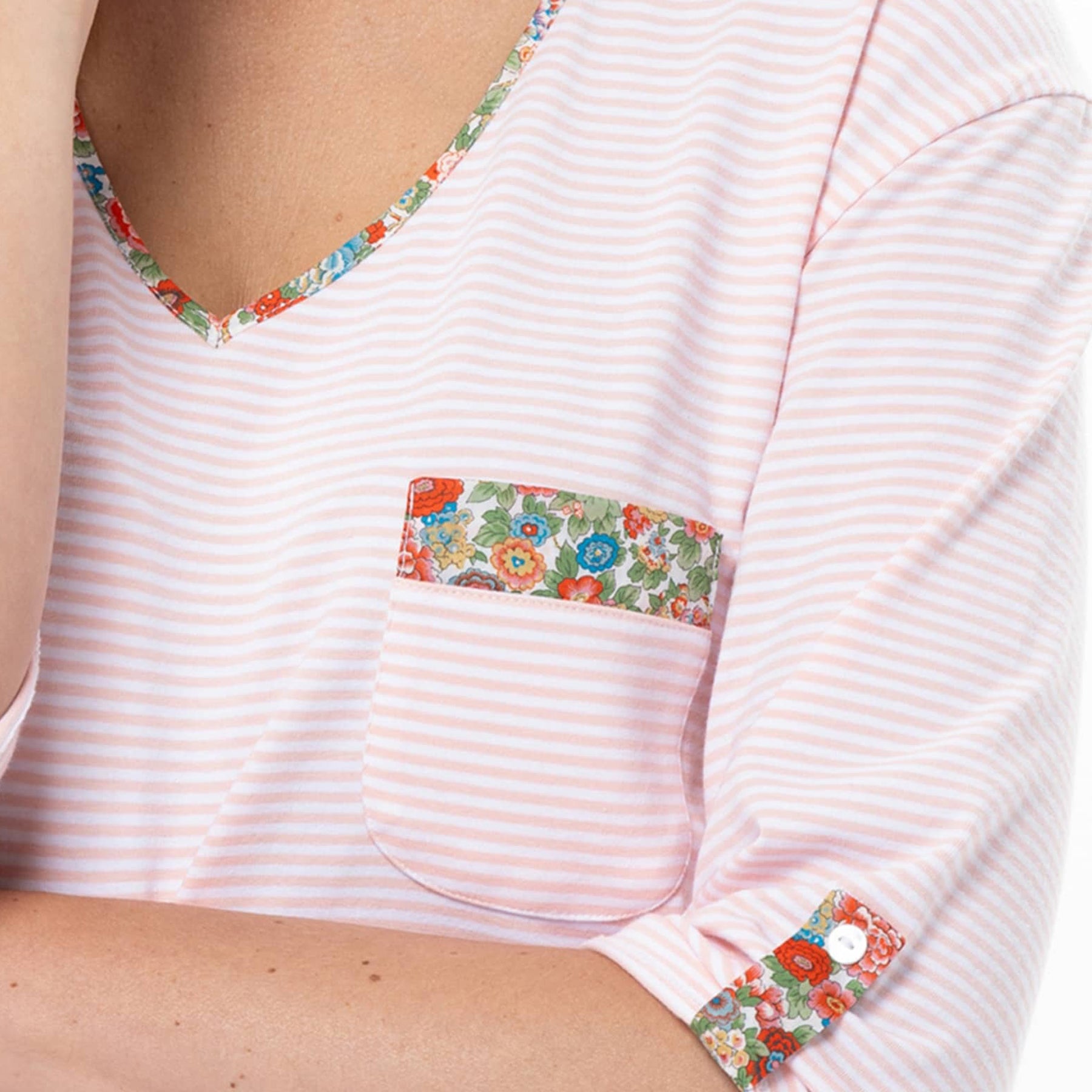 Close-up of pink striped cotton nightdress with floral trim pocket and V-neck detail