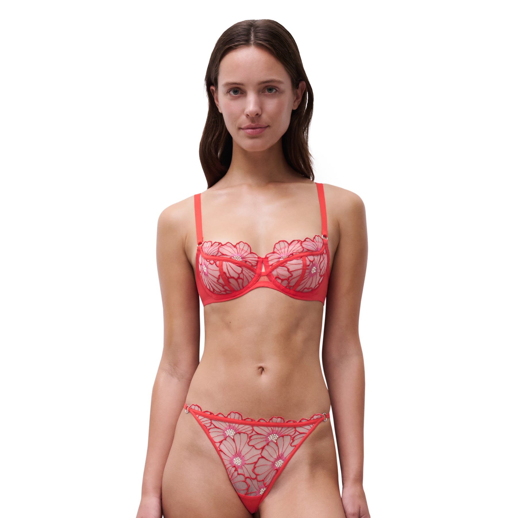 Woman wearing a red lace lingerie set on a white background