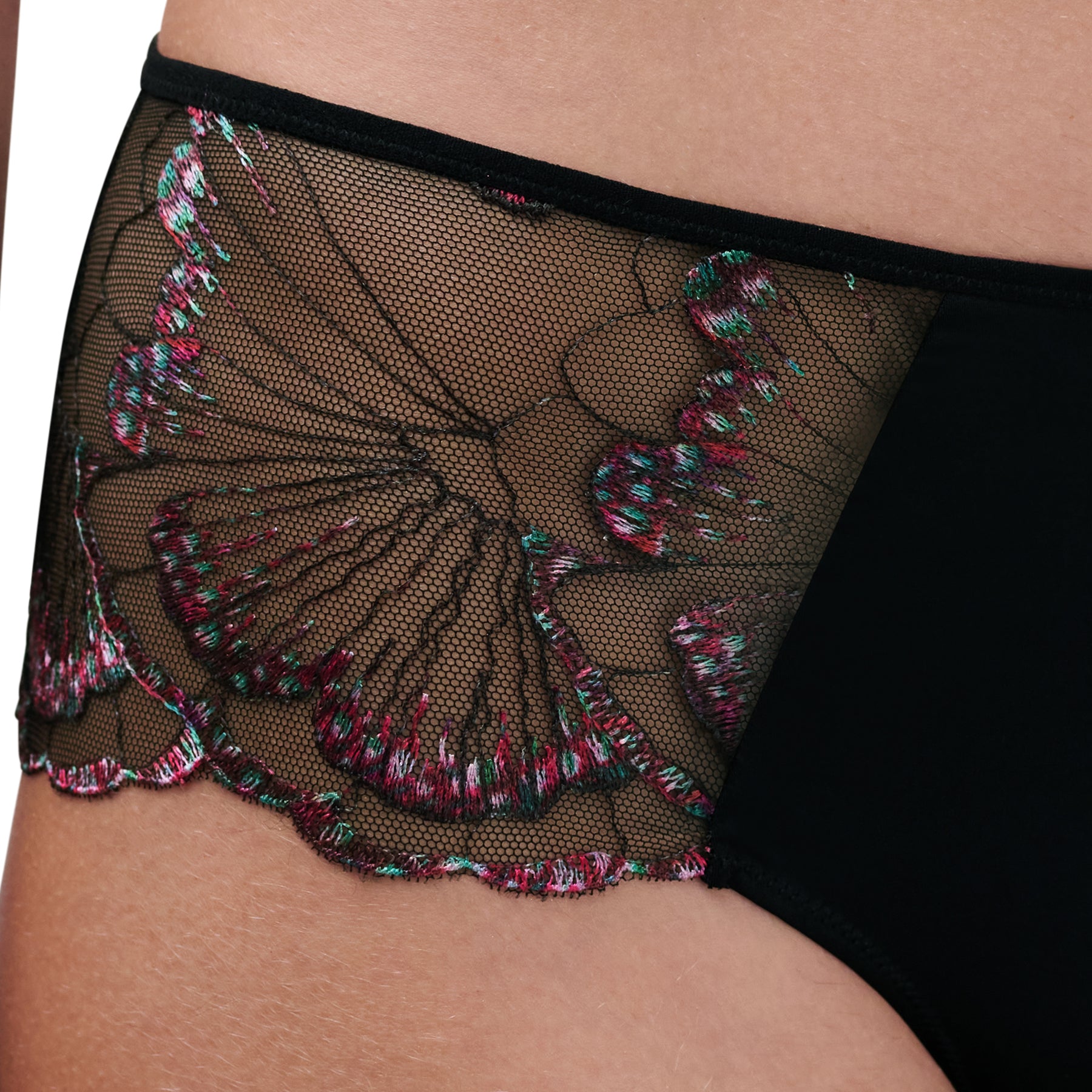 Close-up of black lace briefs showing detailed multicoloured floral embroidery on sheer mesh.