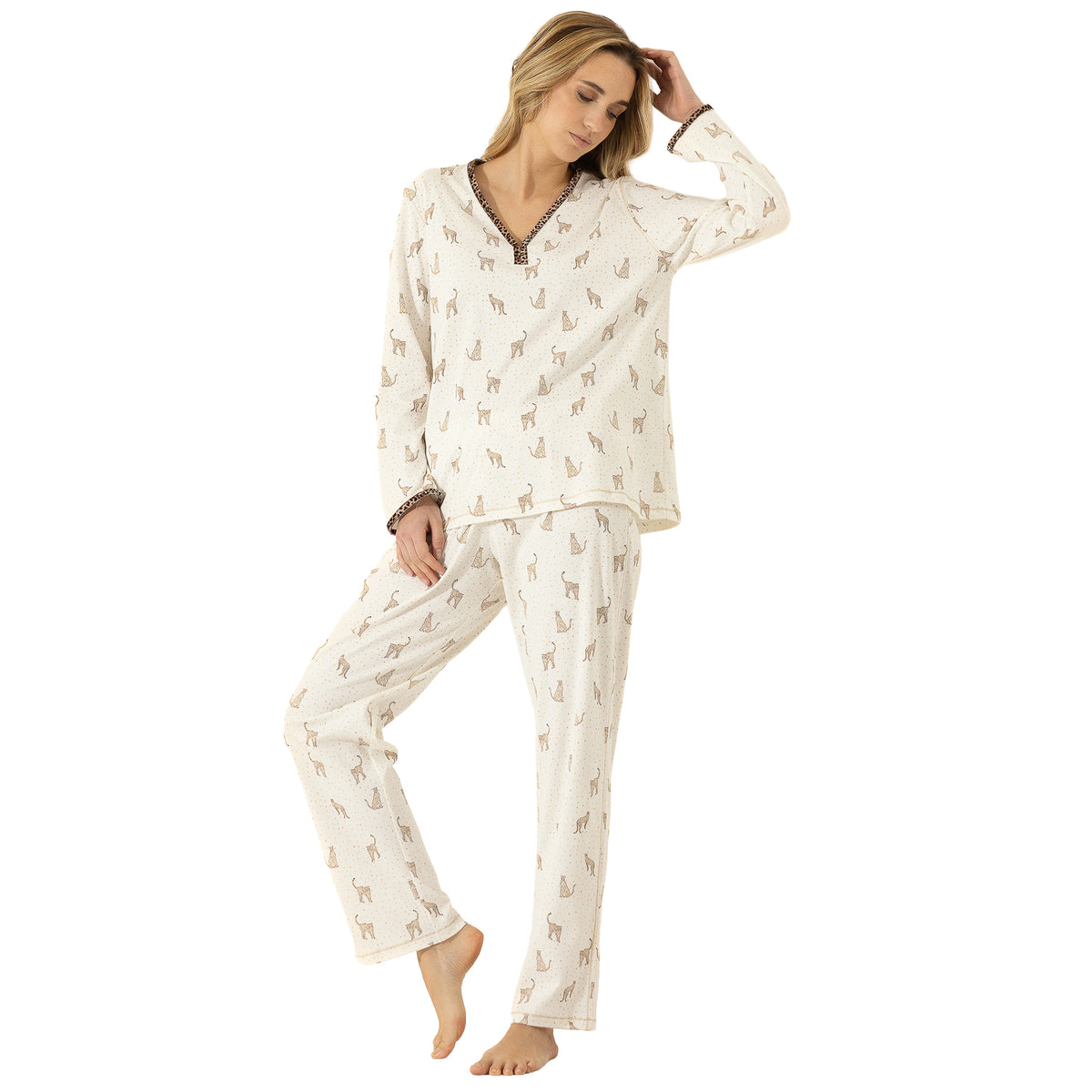 Woman wearing an ivory leopard print pajama set with a relaxed long-sleeve top and coordinating full-length pants.