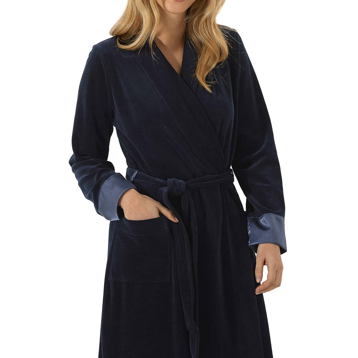 Close-up of a navy velour wrap robe featuring a soft crossover neckline, belted waist, patch pocket, and blue satin cuffs.