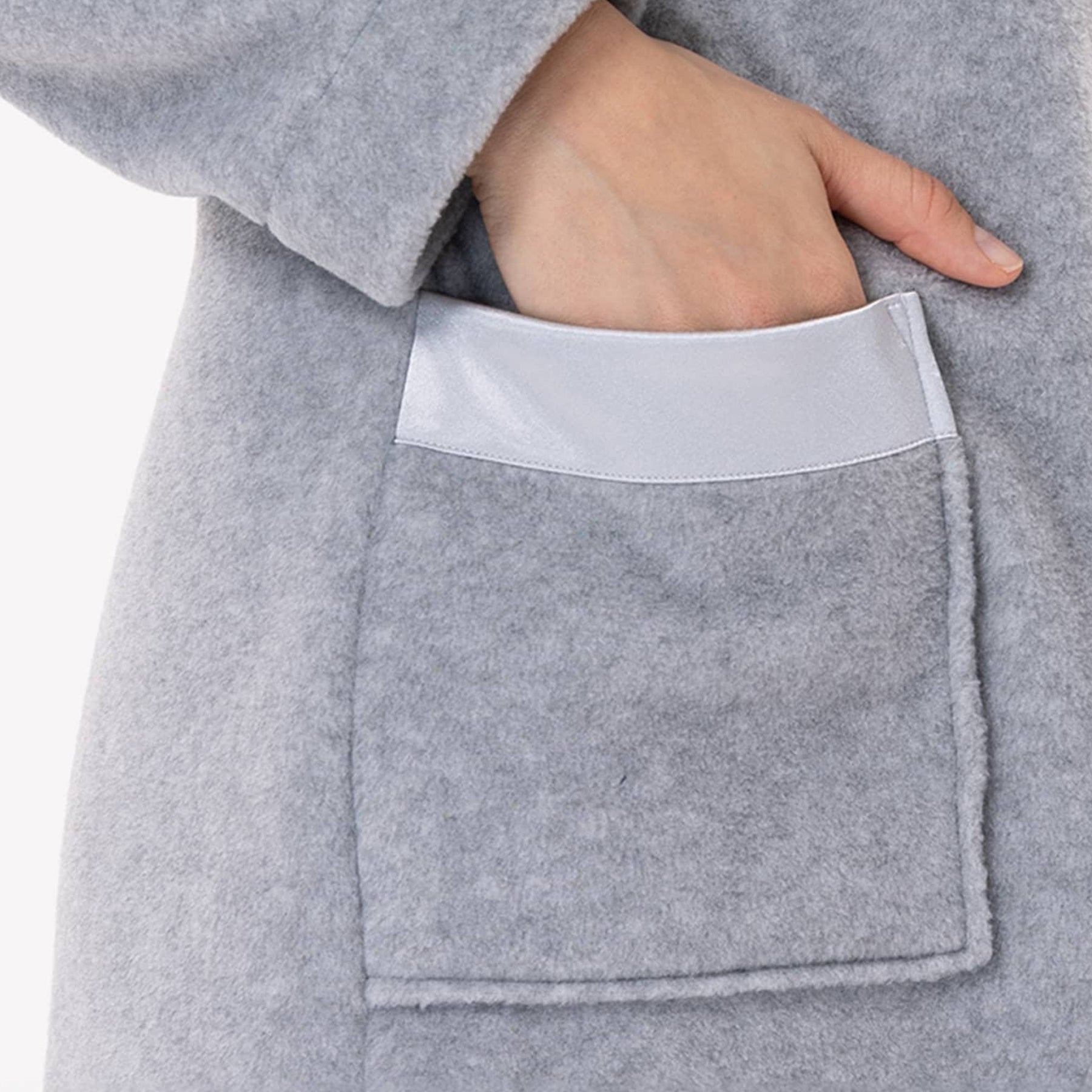 Close-up of satin-trimmed pocket on light grey fleece robe.
