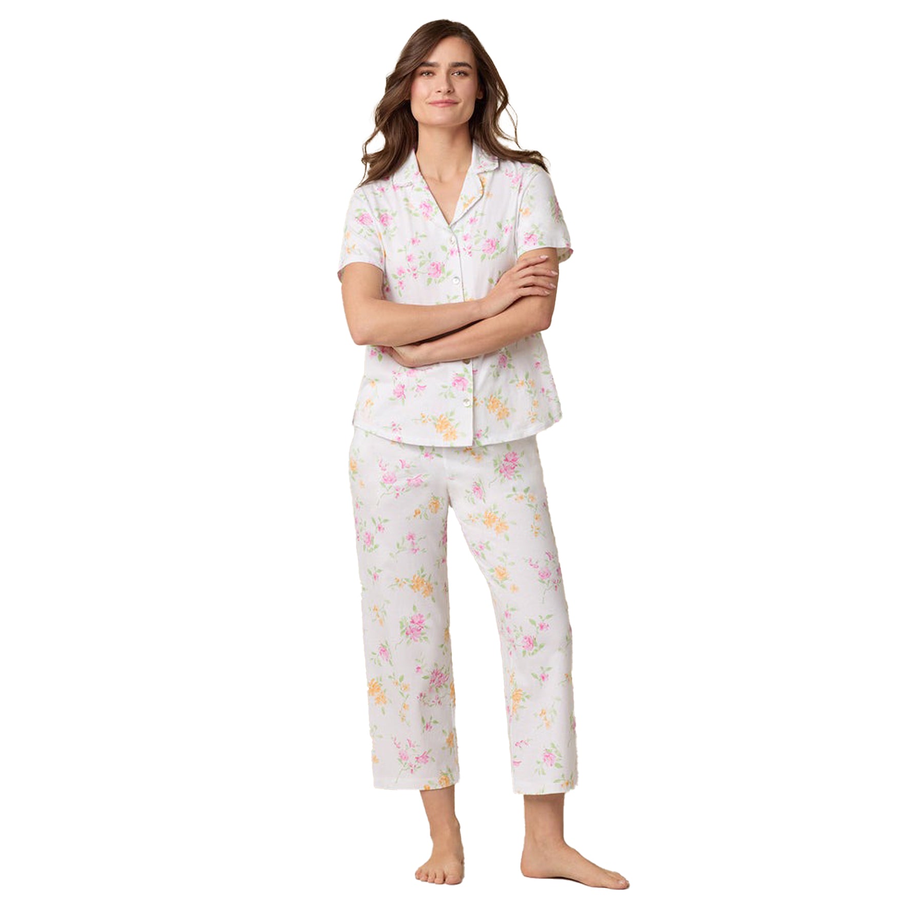 Woman standing in a relaxed pose, wearing a white floral cotton pajama set with short sleeves.