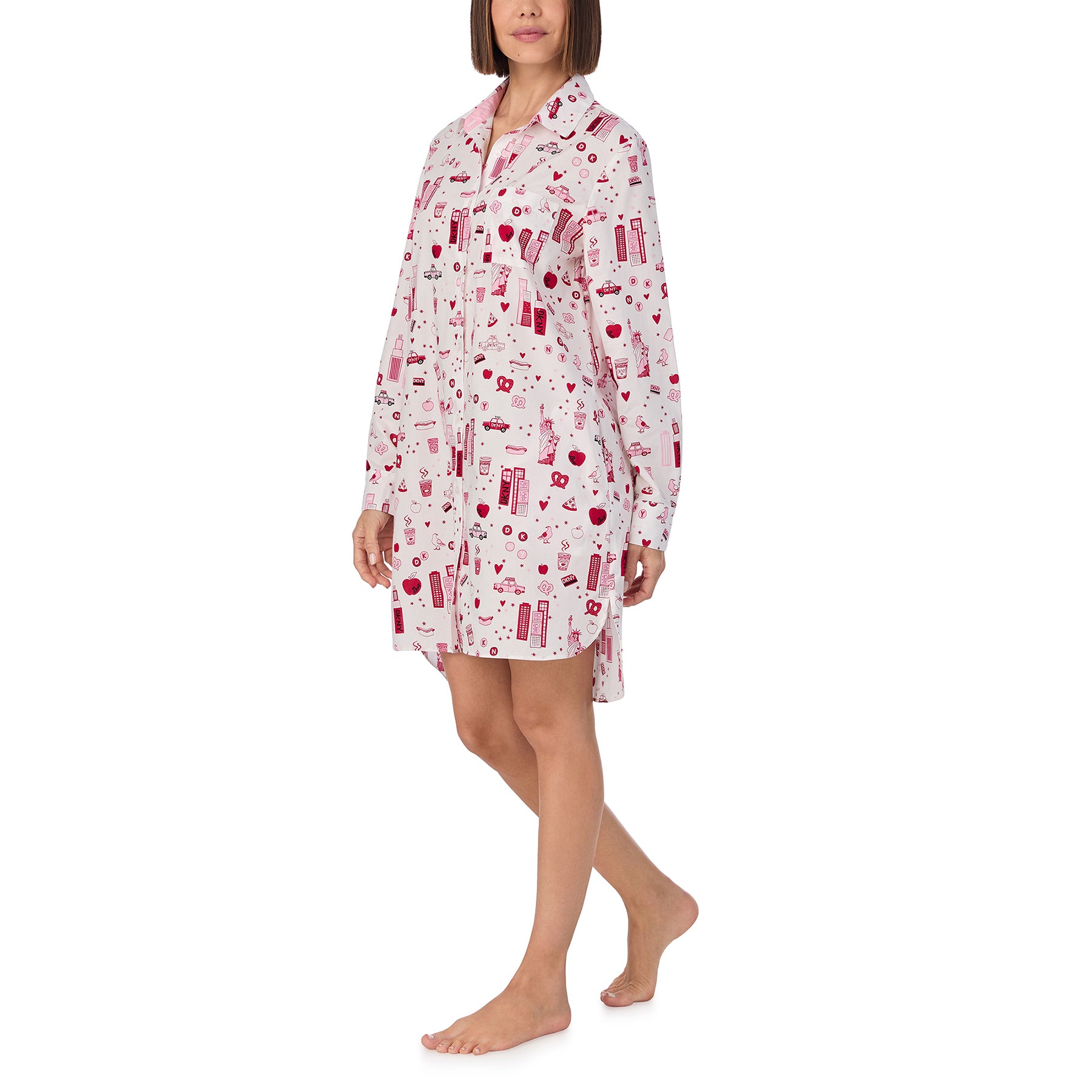 Long sleeve collared button up sleepshirt printed with new york city items in red and pink on a white background. Front/side view on model.