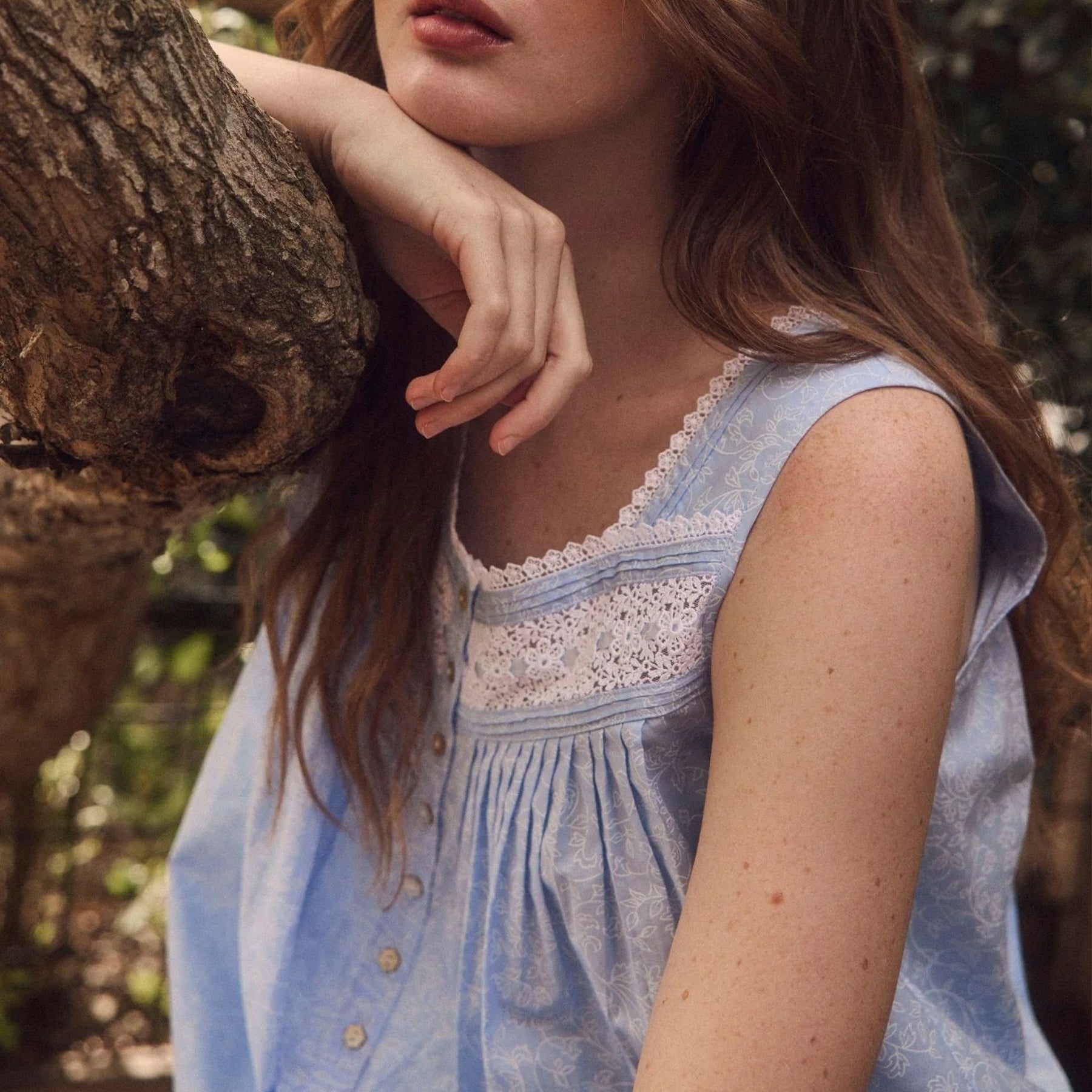 Detail shot of lace neckline and strap on light blue floral cotton nightgown with feminine trim