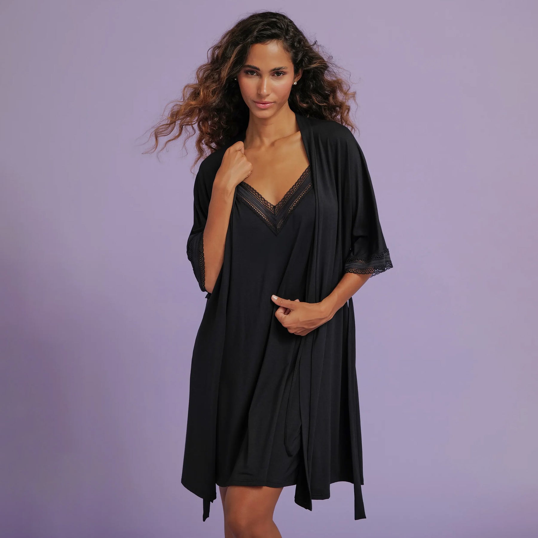 A model wearing the black robe over a matching lace-trimmed nightdress, styled open to reveal the coordinating set.