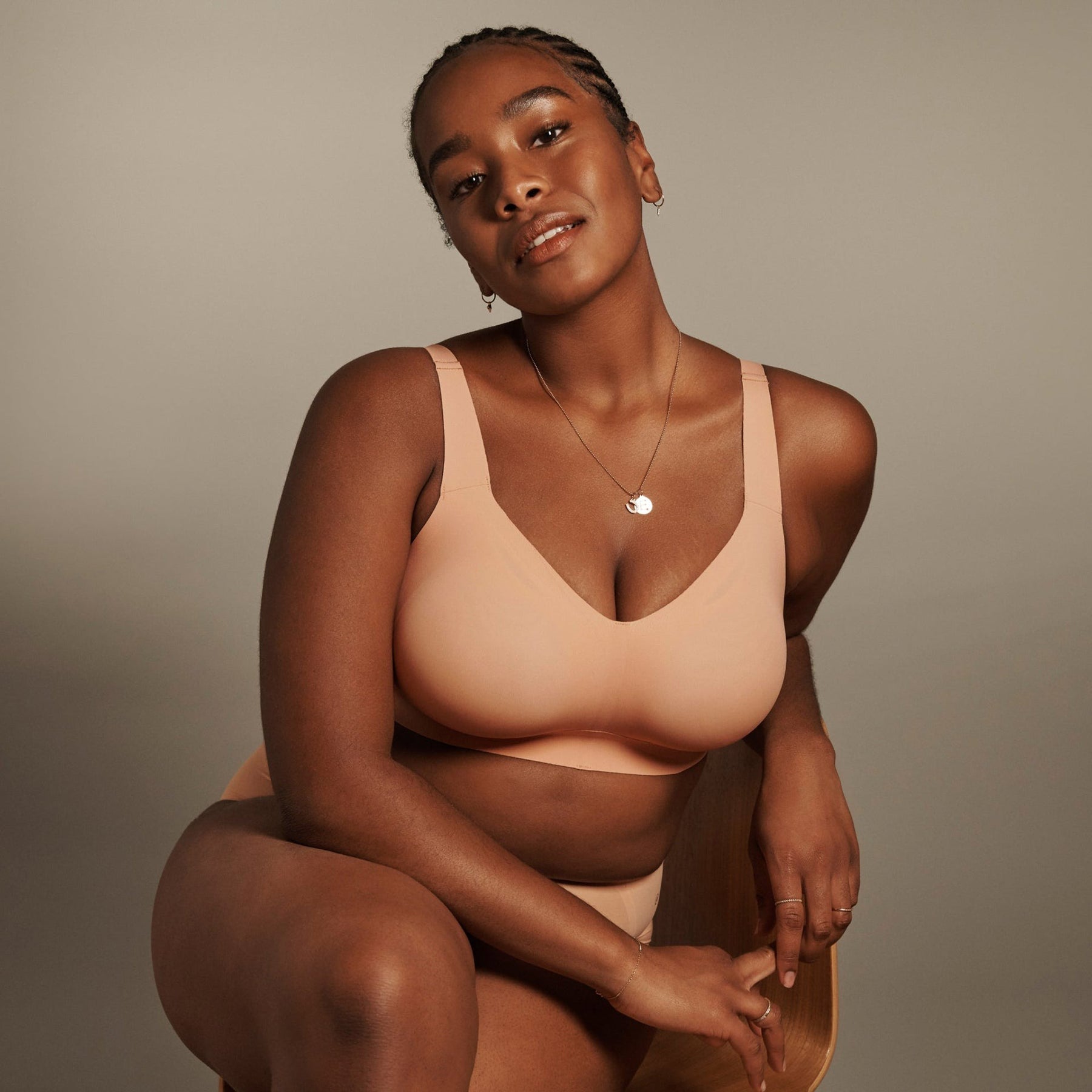 Close-up front view on model sitting in chair, wearing Evelyn & Bobbie Himalayan Salt Beyond Wireless Bra