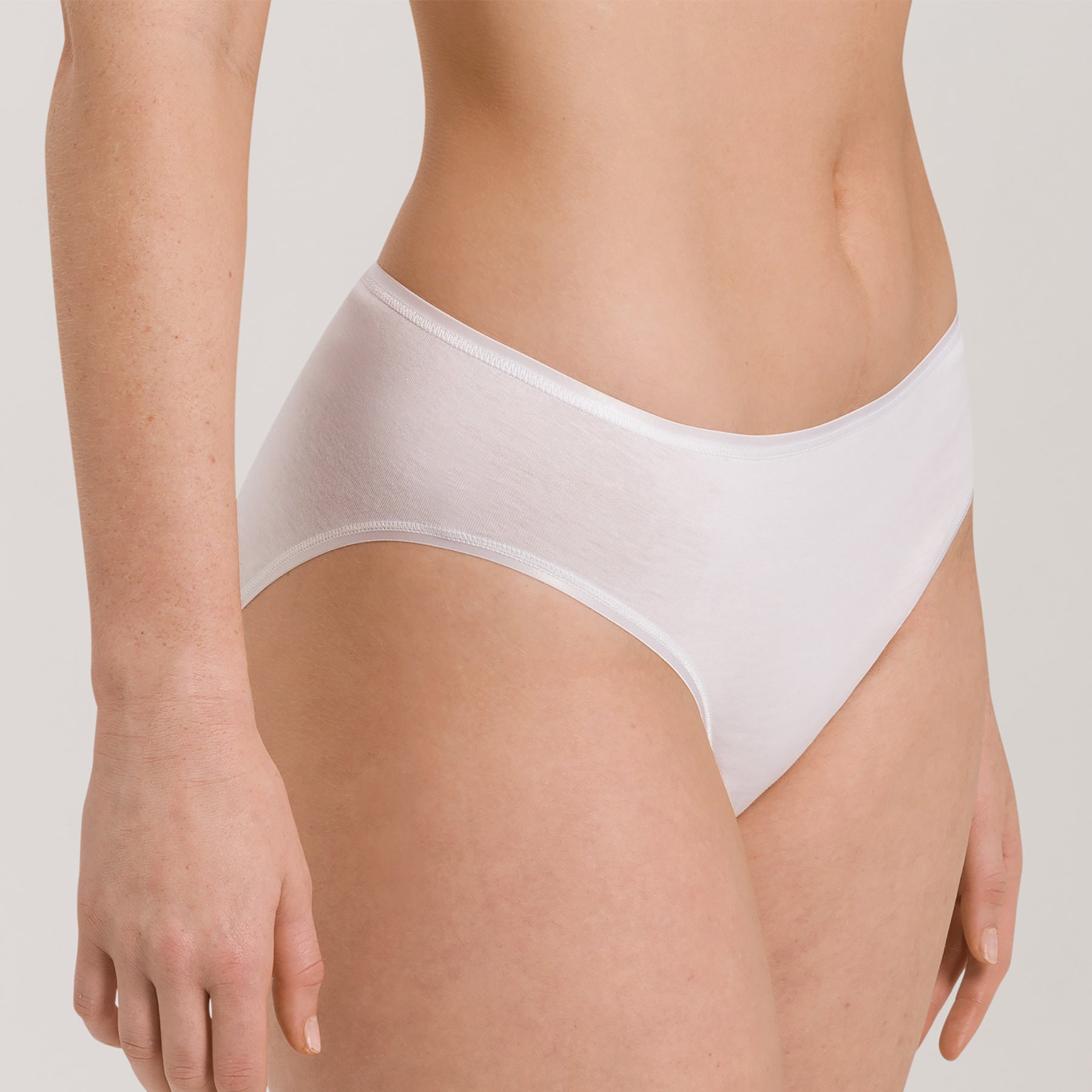 Side angle of Hanro Cotton Seamless Bikini Panty in White with seamless leg openings for a barely-there fit.