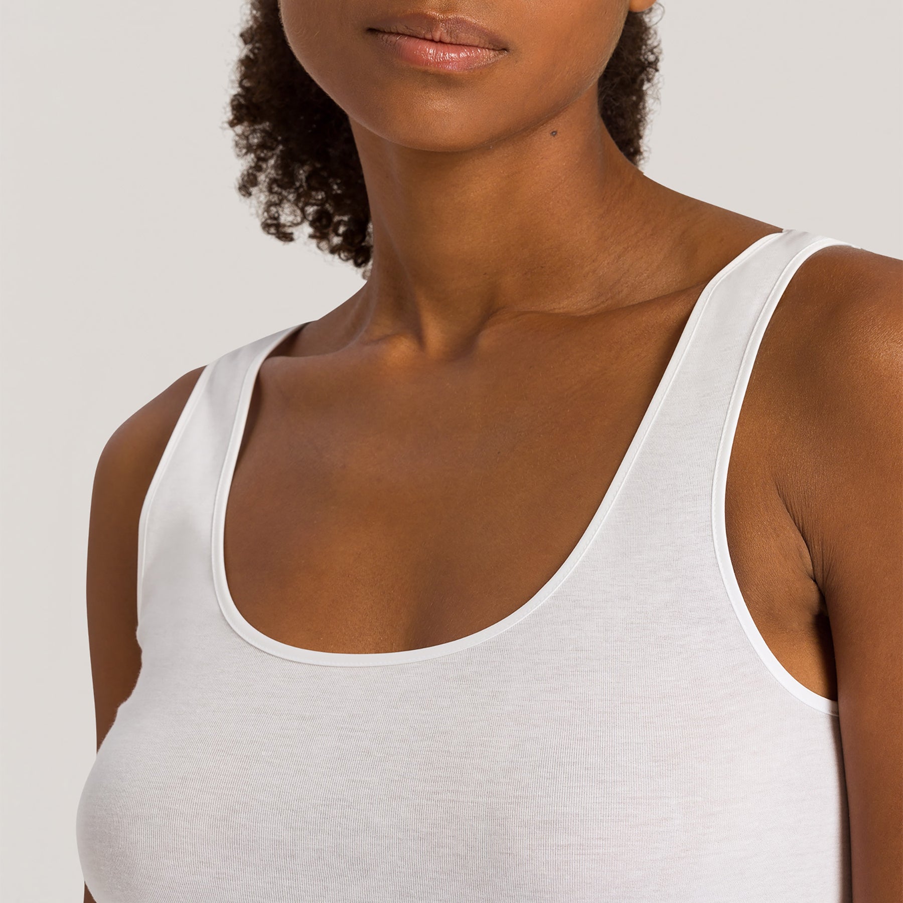 Close-up of scoop neckline and subtle trim detail on Hanro Cotton Seamless Tank in White.