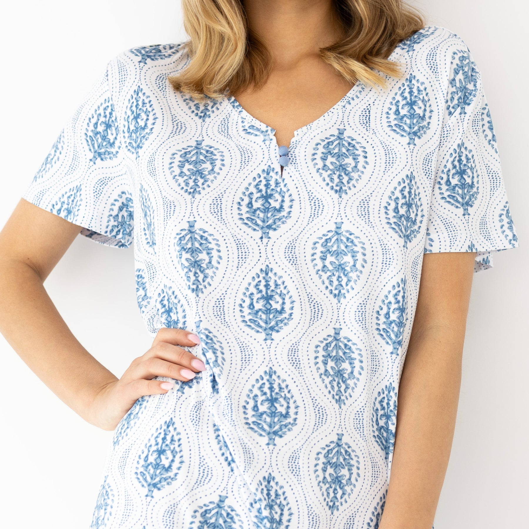 Close-up of blue and white patterned nightdress in lightweight fabric, featuring a soft neckline with button detail and fluid drape