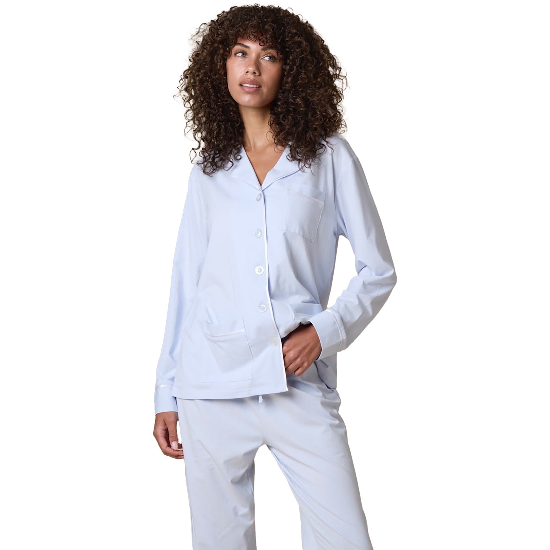 Classic cotton button up pyjama set in baby blue with contrast white piping. Front view closeup on model.