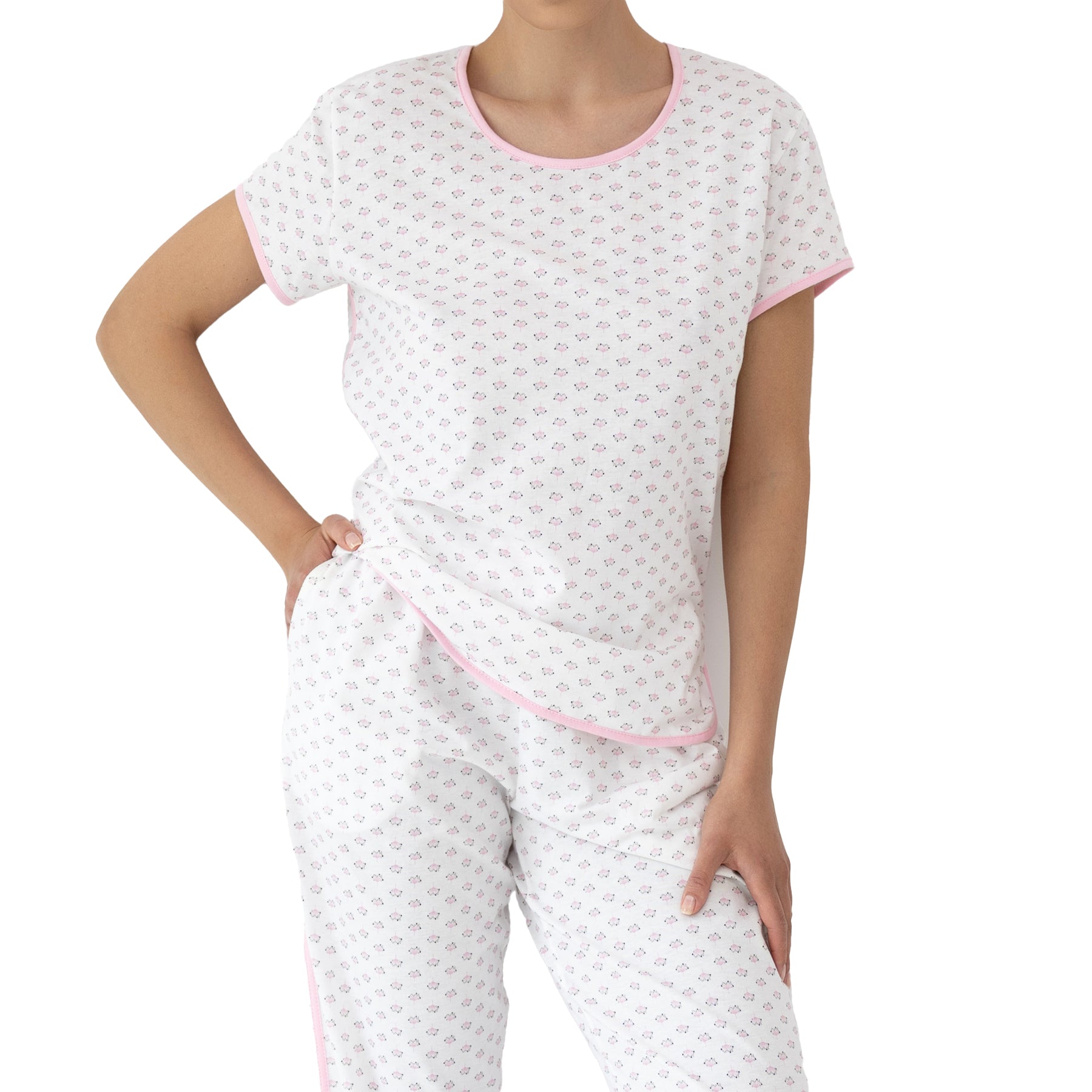 Close-up of white pyjama set with delicate pink floral print, short-sleeve top, and soft fabric with pink trim detailing