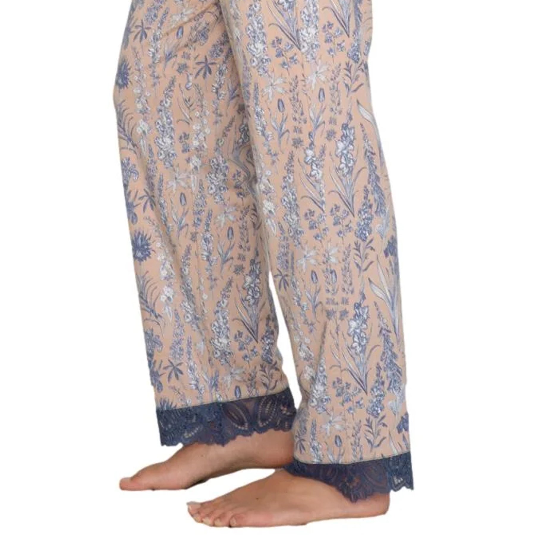 Close-up of floral print pajama pants in beige and blue with delicate lace trim at the hem
