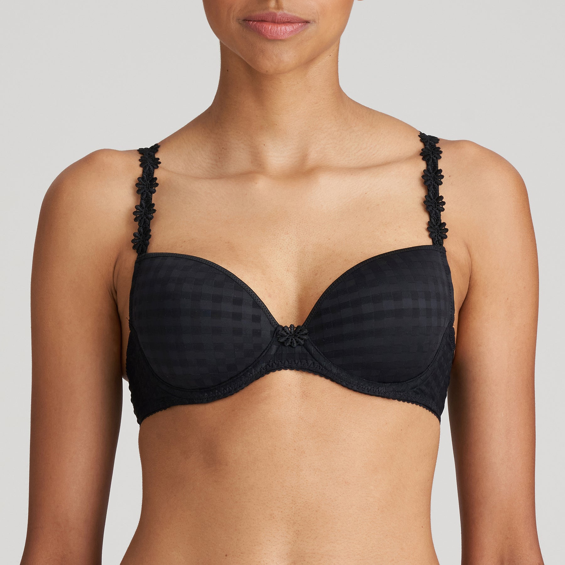 Padded plunge bra in black with checkerboard print and embroidered daisy straps. Front view on model.