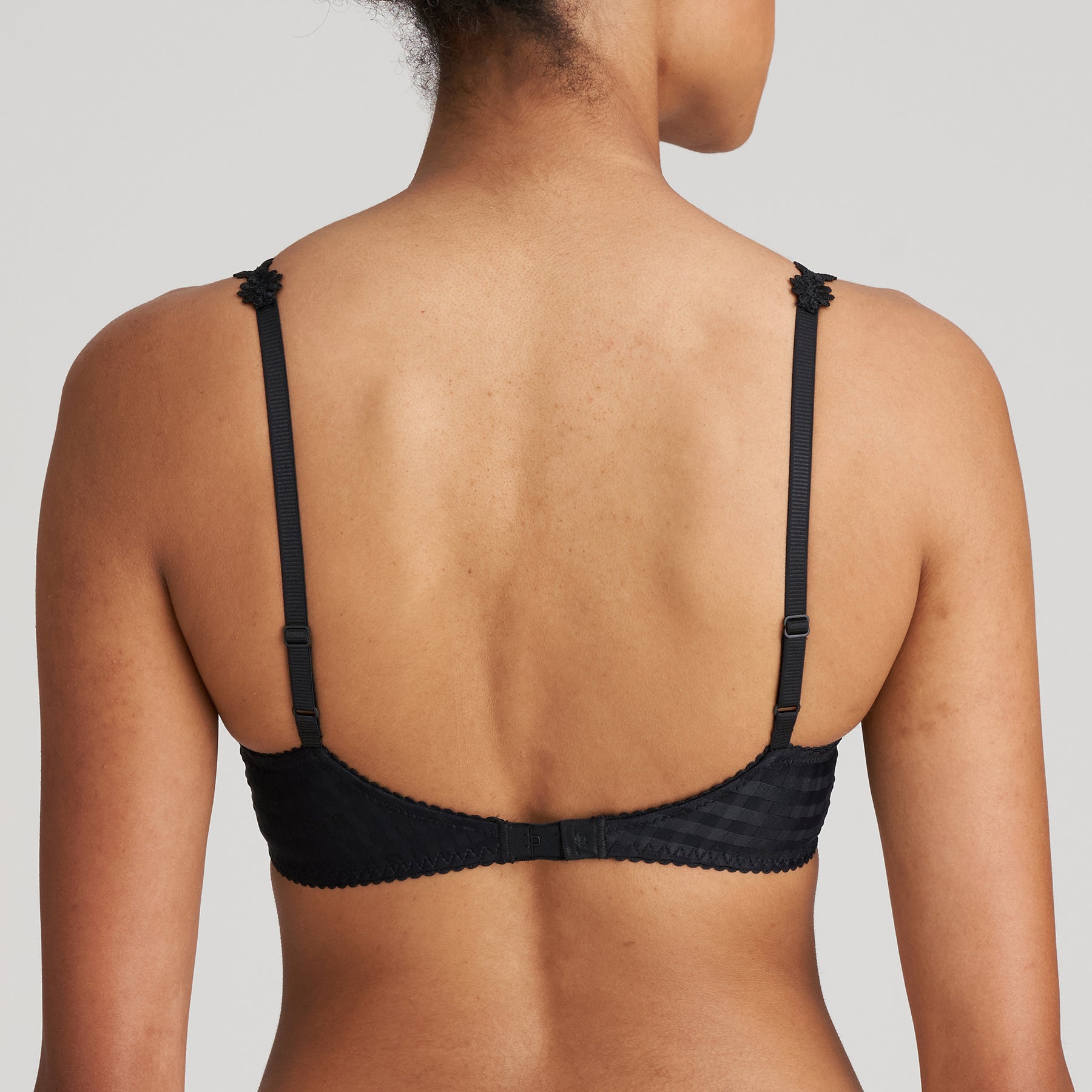 Padded plunge bra in black with checkerboard print and embroidered daisy straps. Rear view on model.