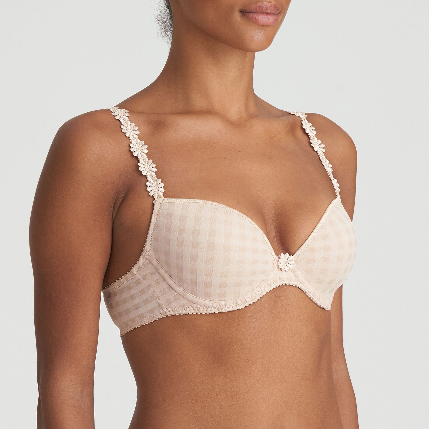 Padded plunge bra in nude cafe latte with checkerboard print and embroidered daisy straps. Side view on model.