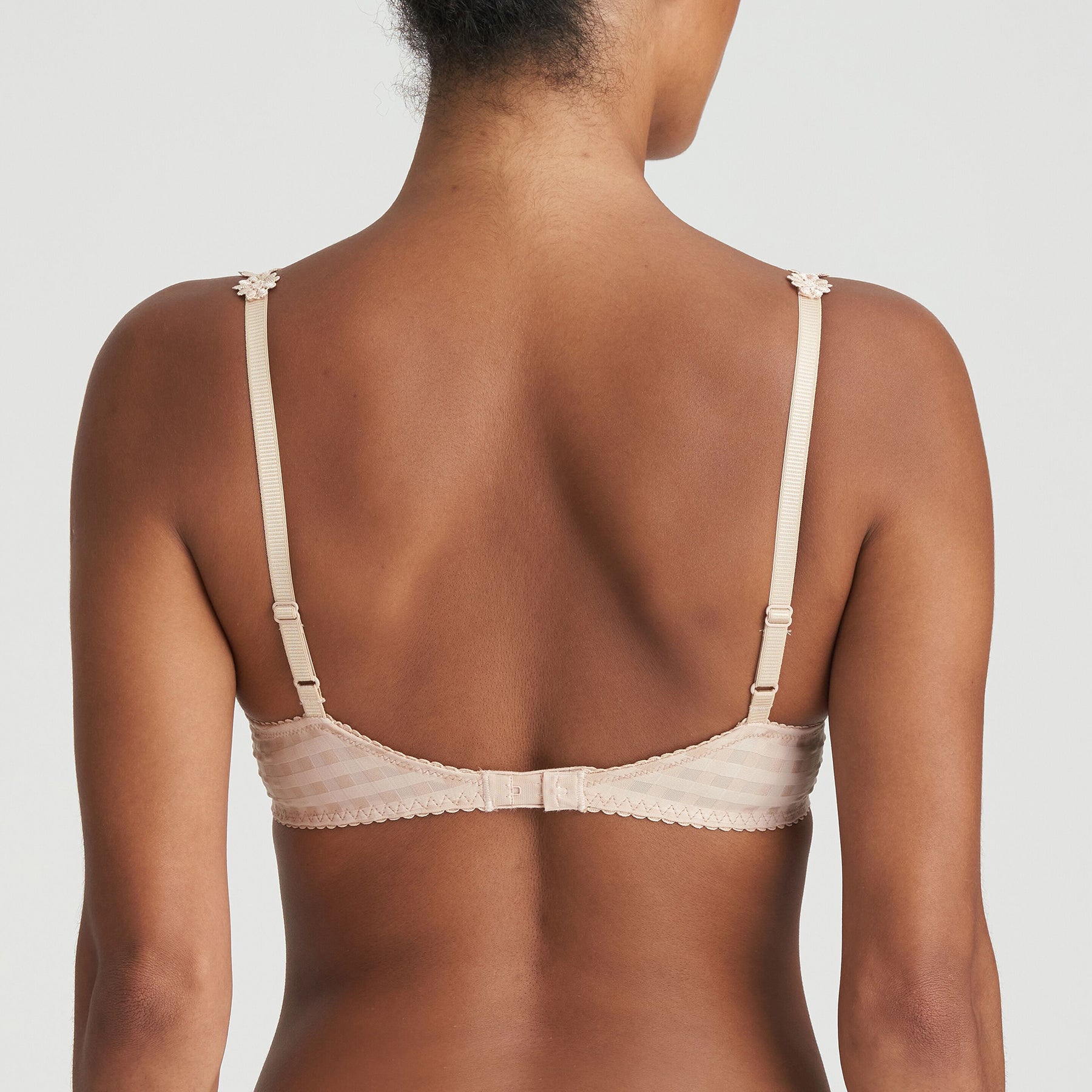 Padded plunge bra in nude cafe latte with checkerboard print and embroidered daisy straps. Rear view on model.