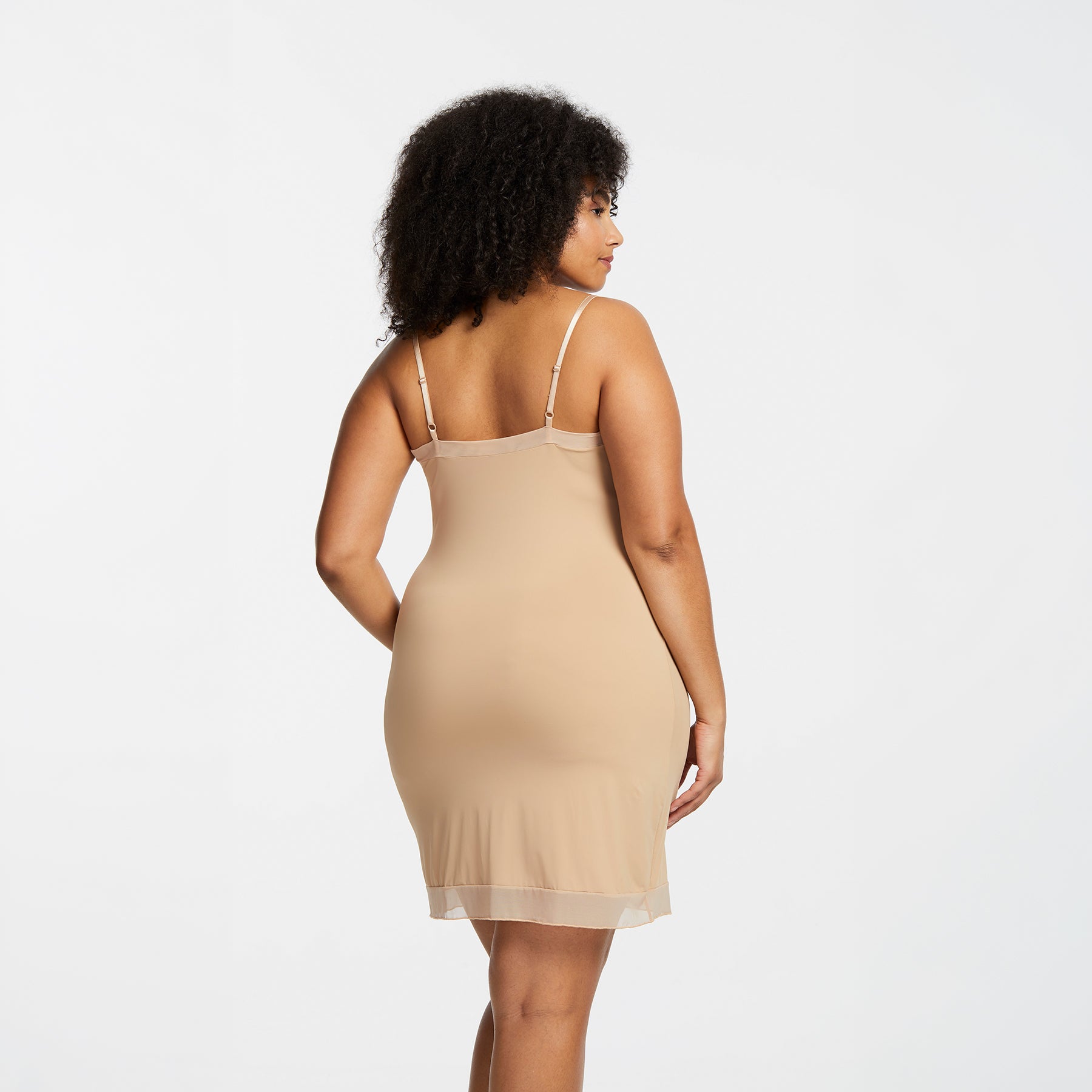 Montelle Intimates 9500 V-neck slip at knee in Sand colour with lightweight smoothing fabric and sheer trim, angled back view on curvy model.