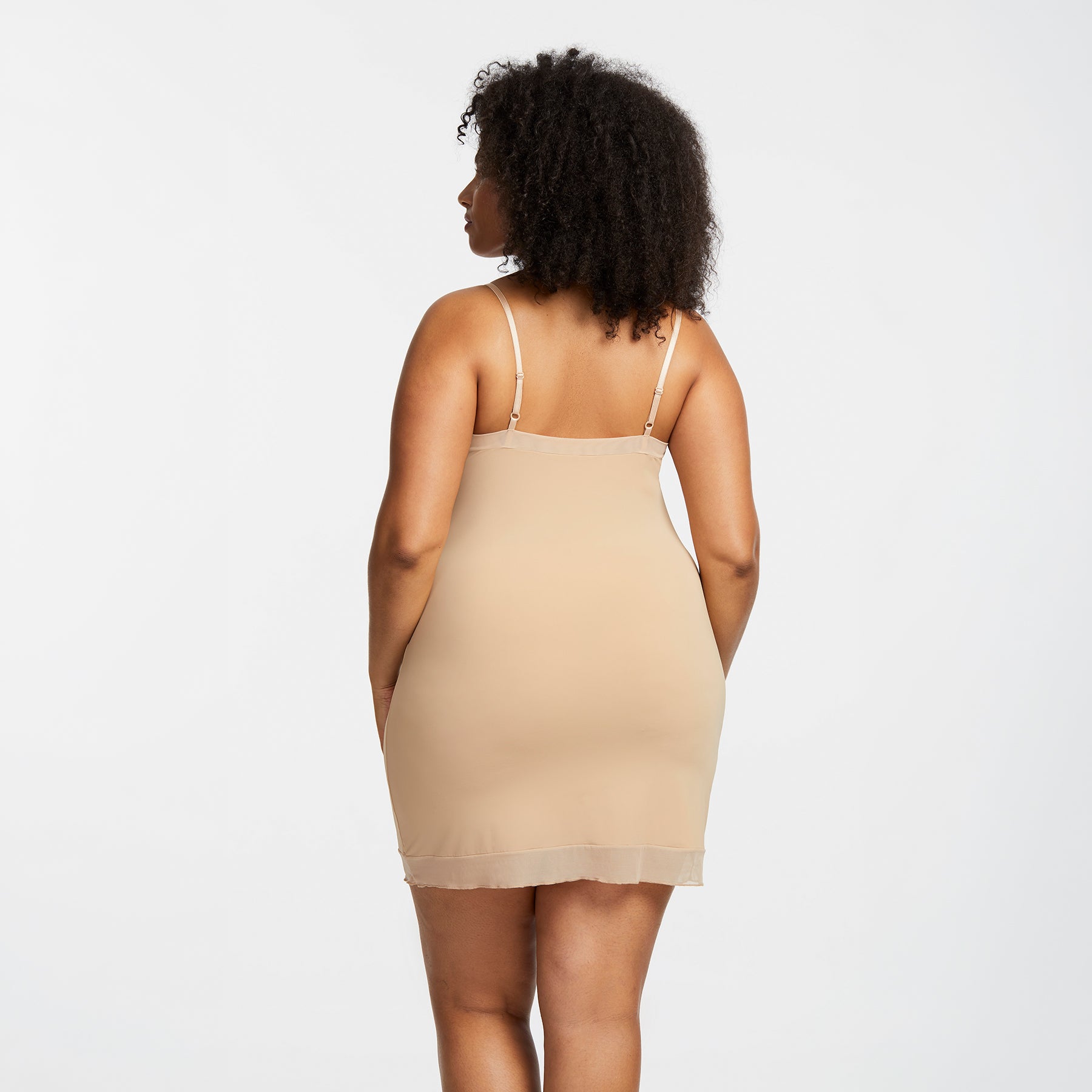 Montelle Intimates 9501 round neck slip above knee in Sand colour with sheer hem detail and adjustable straps, back view on curvy model.