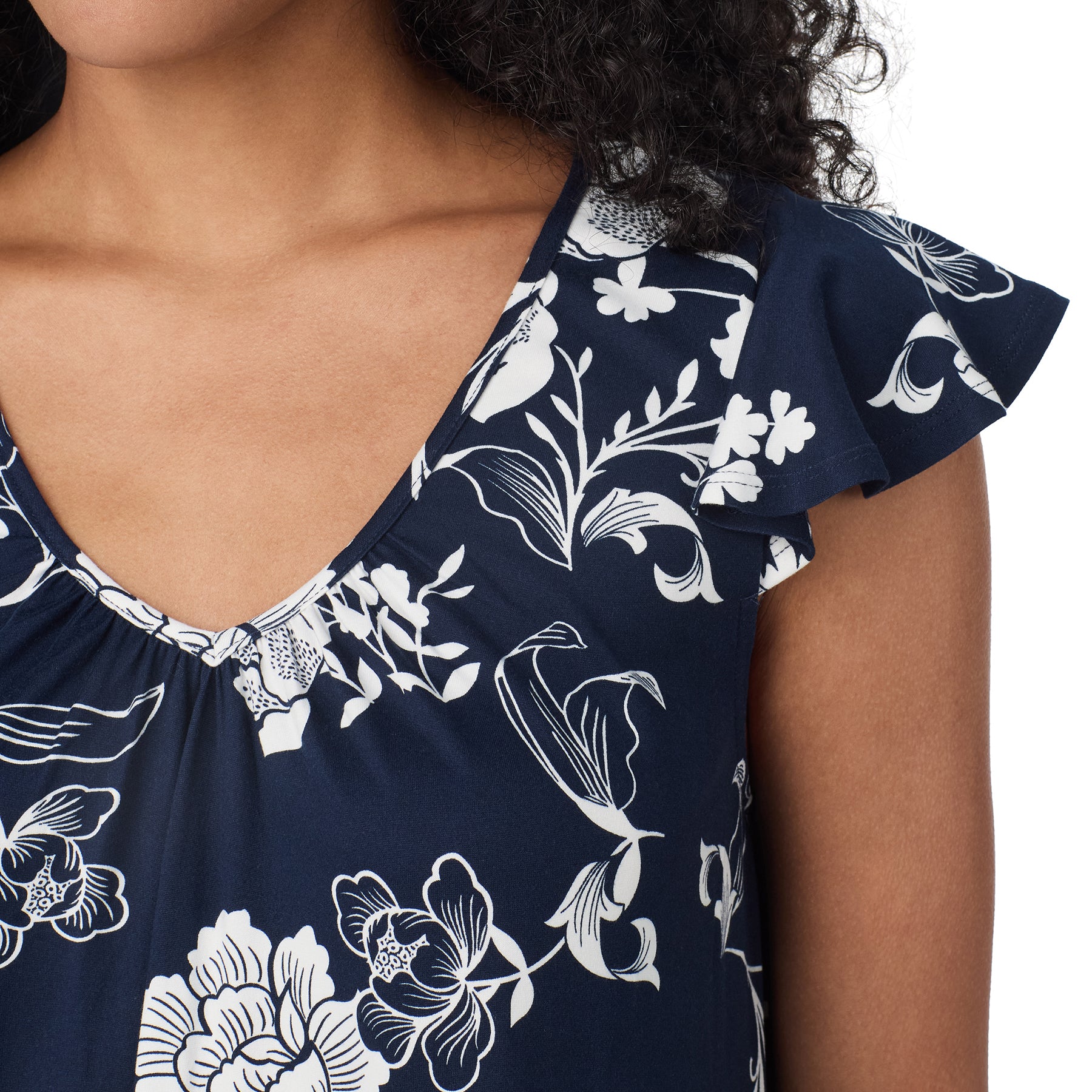 Close-up of navy and white floral nightgown showing the V-neckline, delicate gathers and layered flutter sleeve detail.