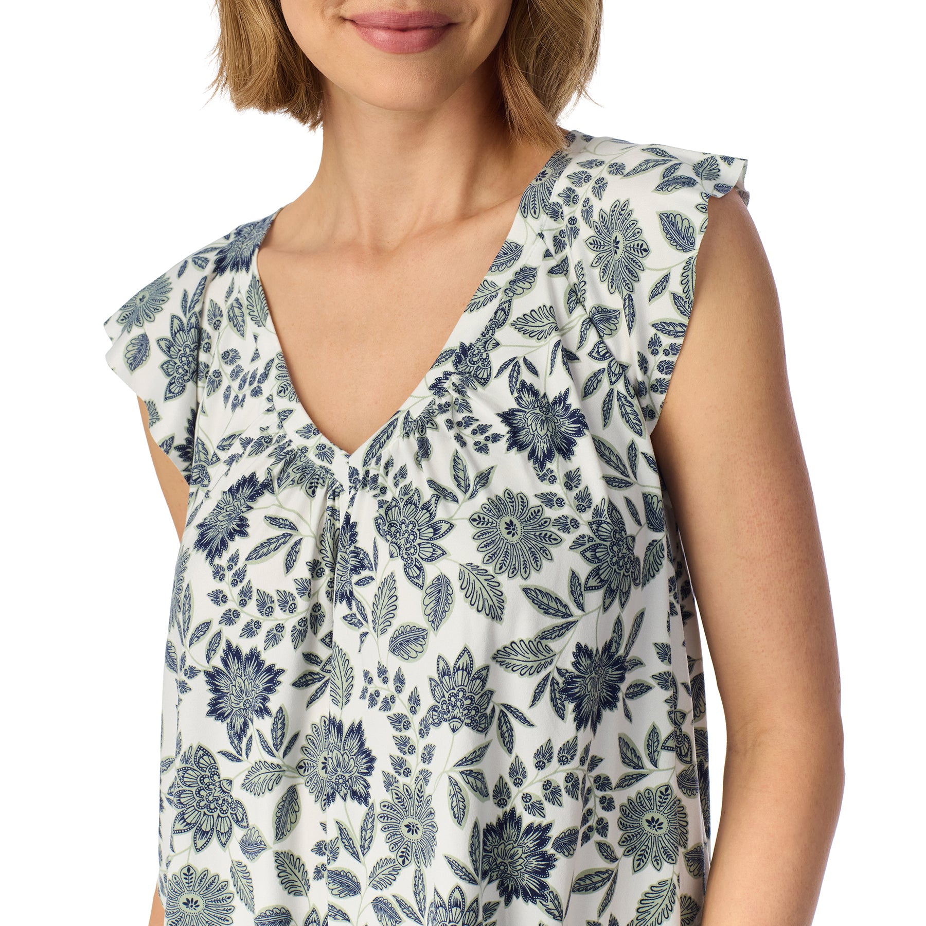 Close-up of a women's pajama top featuring a white background with an elegant blue floral print, flutter sleeves, and a softly gathered V-neckline.