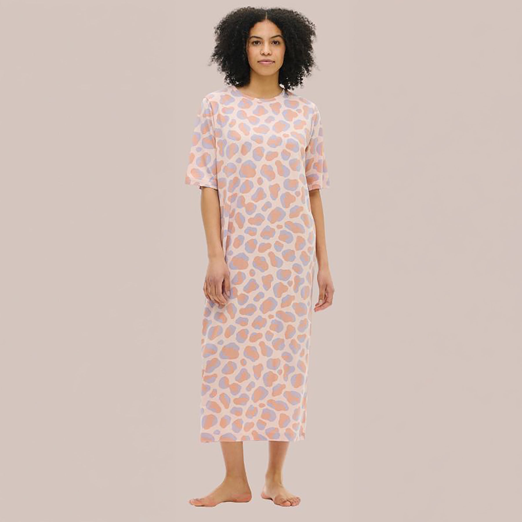 Nanso Pantteri short-sleeve gown in pink animal print – front view on model showing soft cotton fabric and relaxed fit.