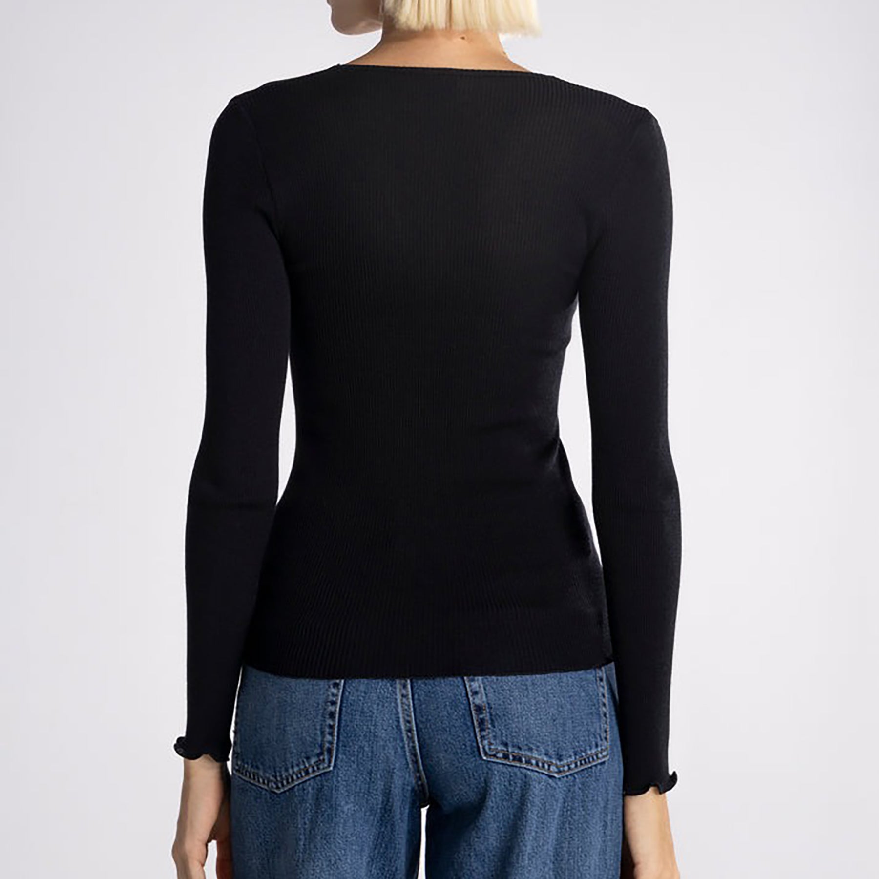 Long sleeve wool and silk blend ribbed top with zipper and rhinestone neck detail in black. On model rear view.