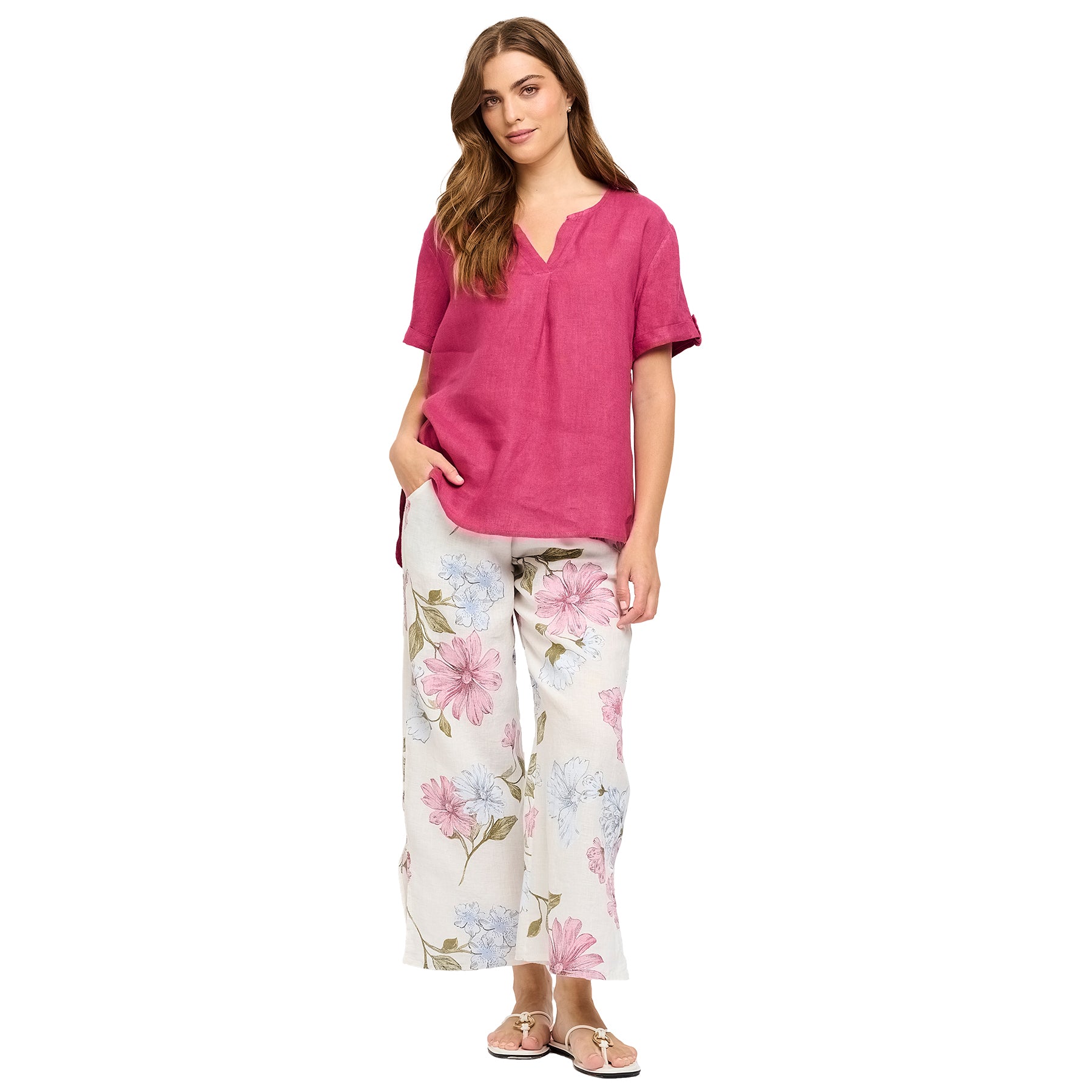 Sky pink floral printed linen pants with split leg hem. Front view on model.