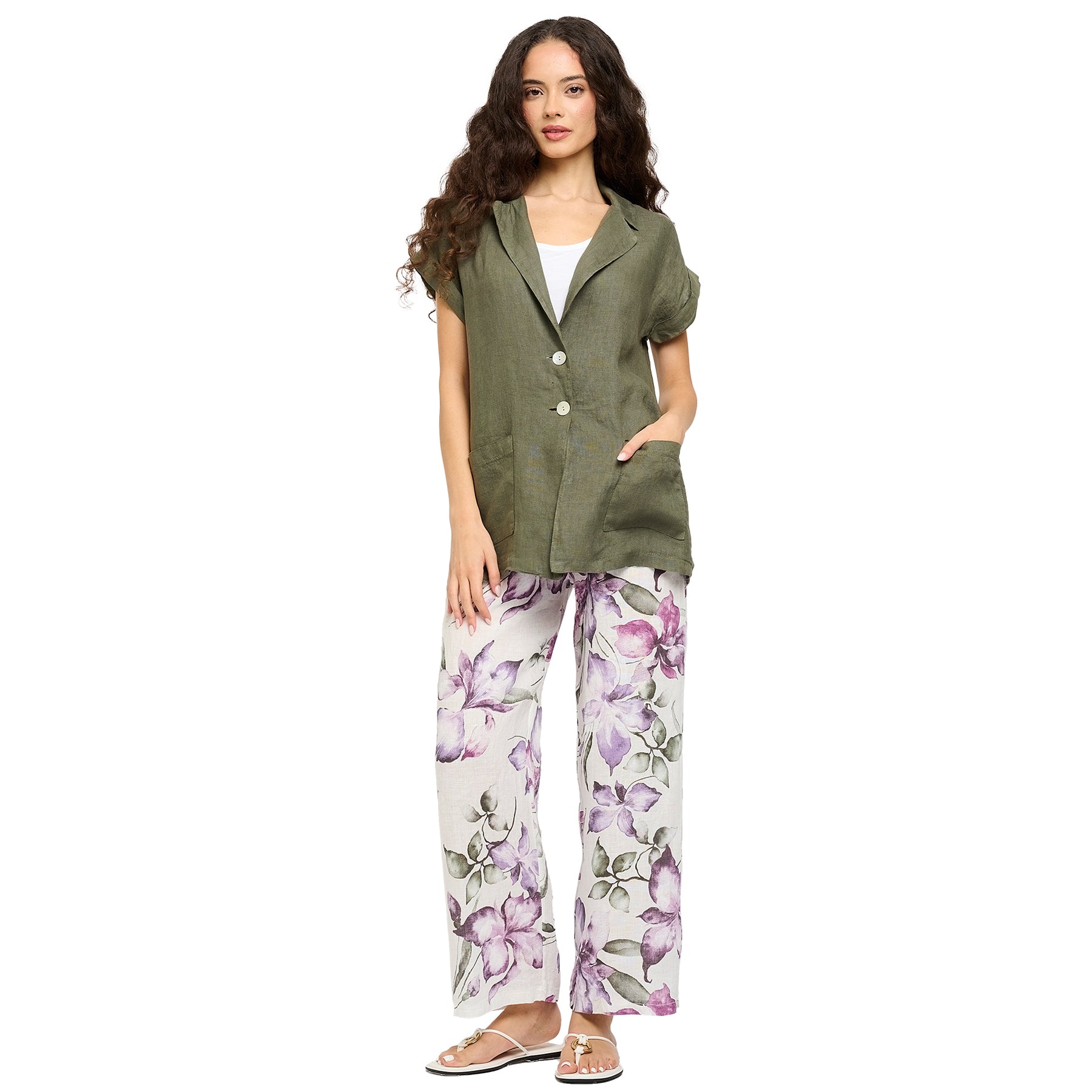 Purple violet/green floral printed linen pants. Front view on model.
