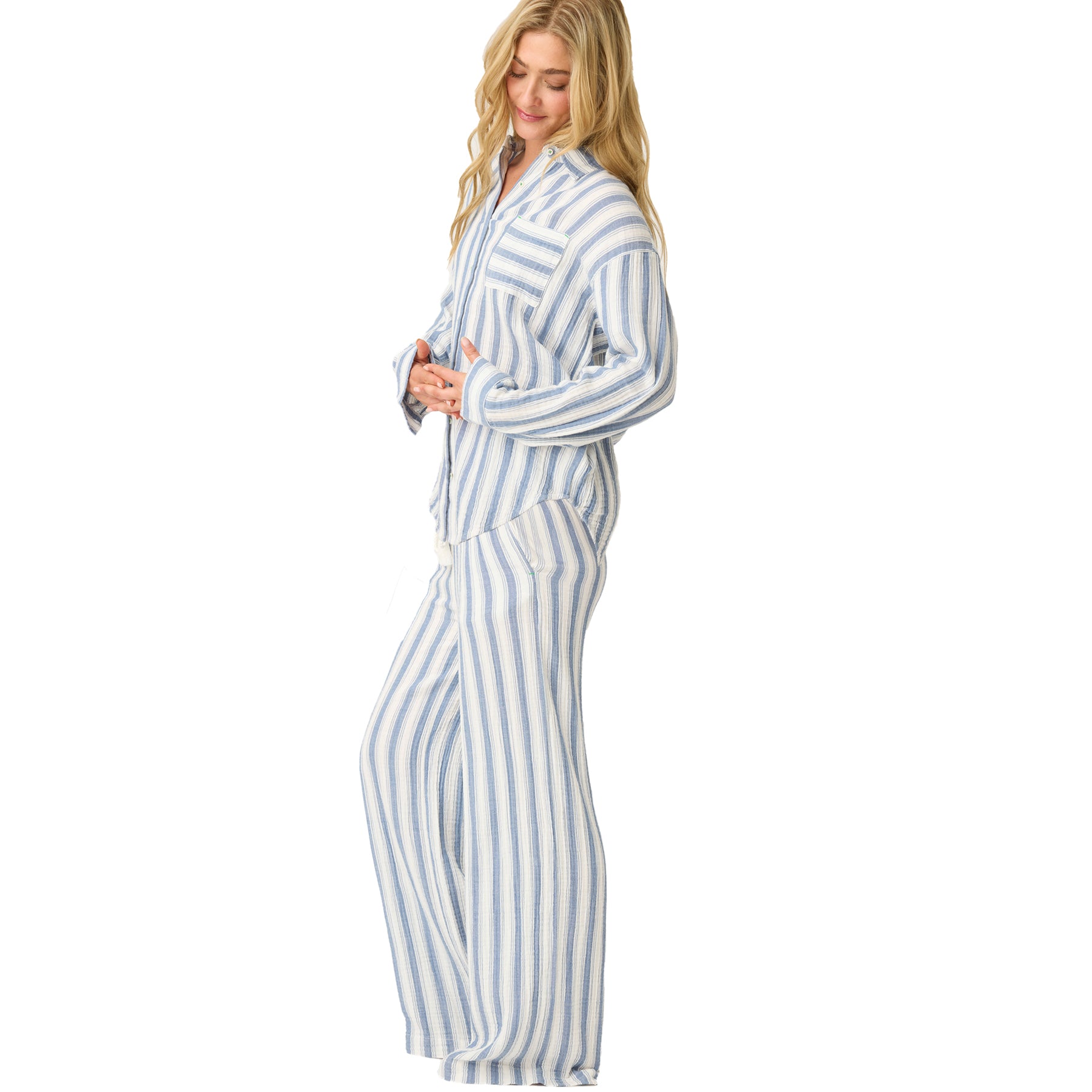 Side view of model wearing blue and ivory striped pyjama set with relaxed long-sleeve shirt and wide-leg pants