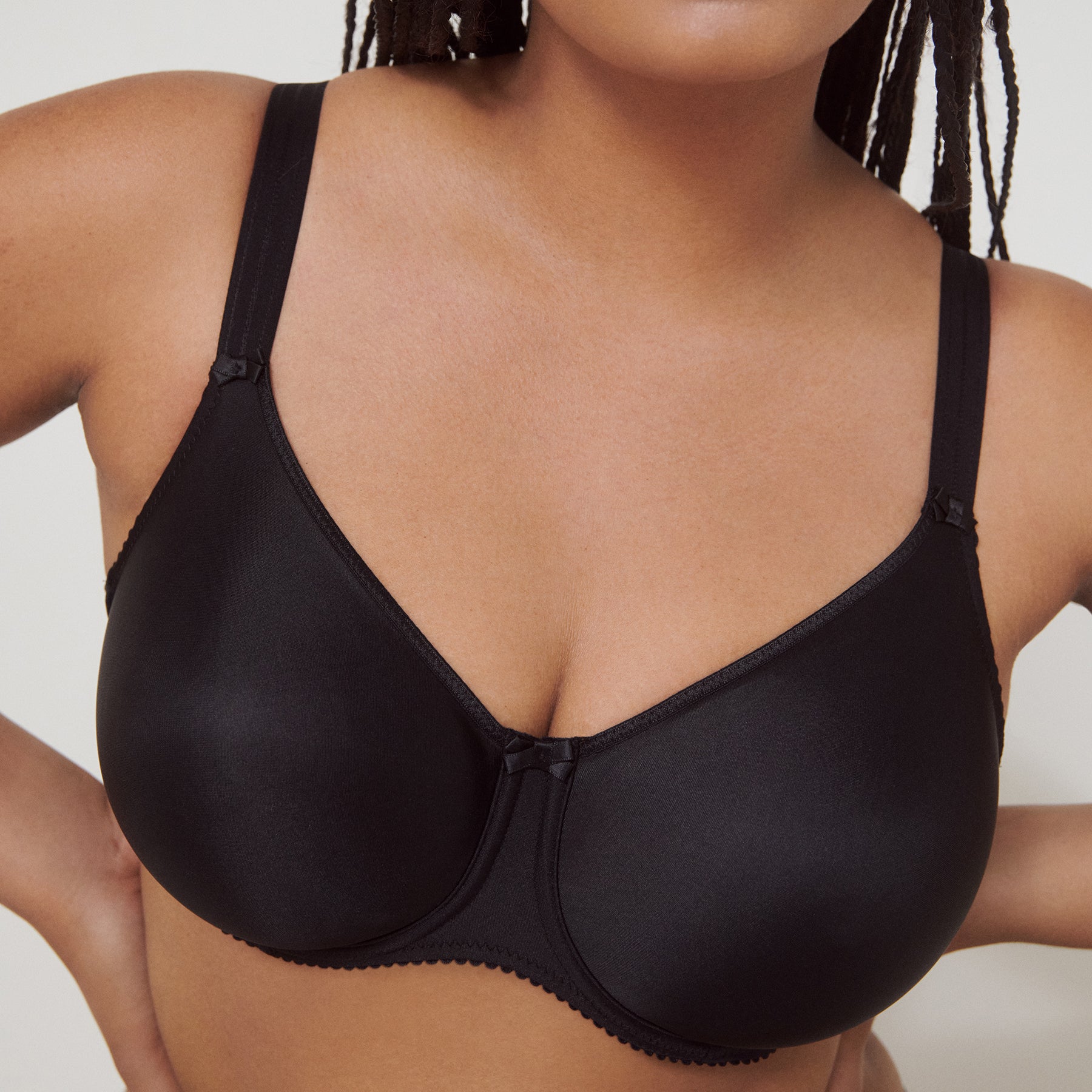 Seamless underwired black bra. Front view, closeup on model.
