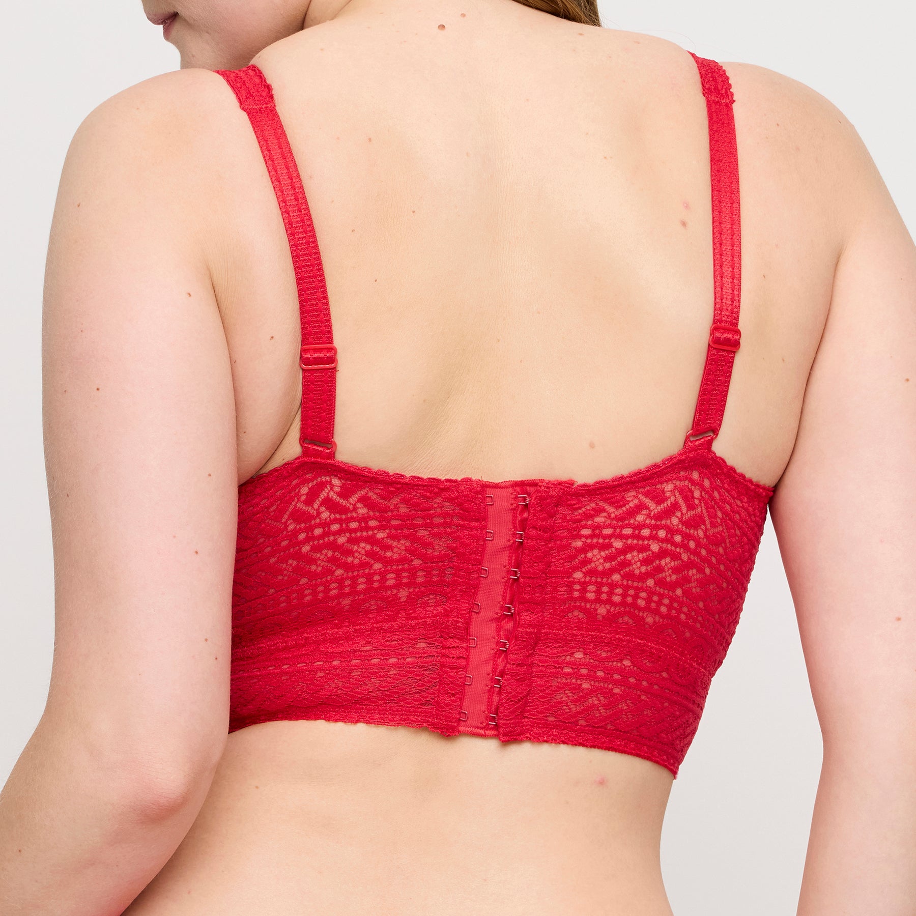 Back view of PrimaDonna Montara wireless plunge bra in true red showing adjustable straps, hook-and-eye closure, and wide lace band