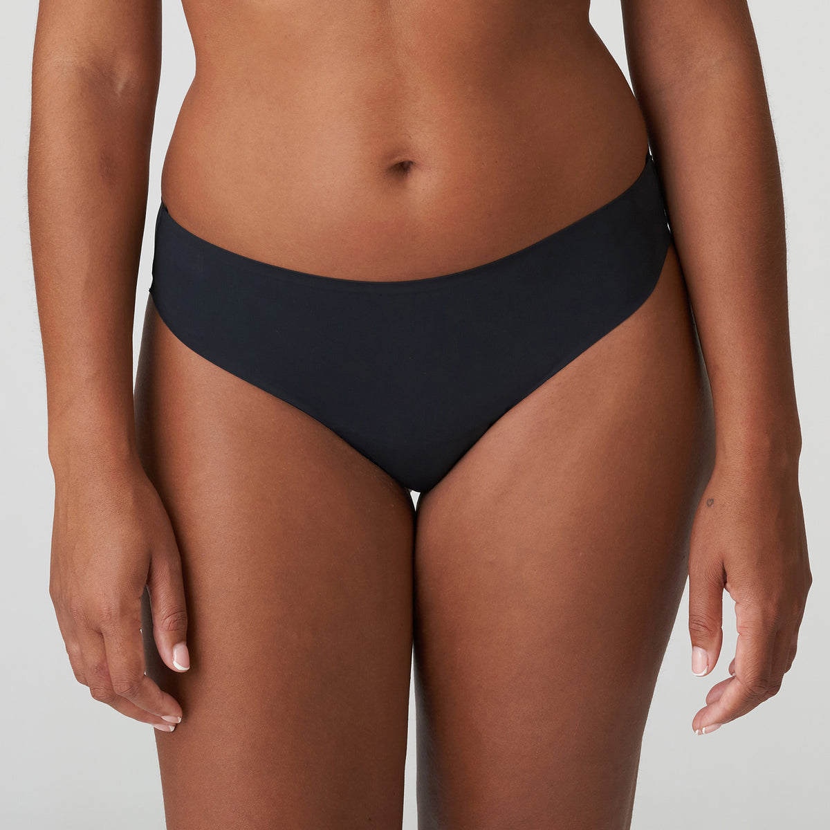 Front view of model wearing PrimaDonna Figuras Seamless Thong Style 0663250 in Charcoal, showcasing a smooth low-rise fit, seamless waistband, and flattering high-cut leg openings.