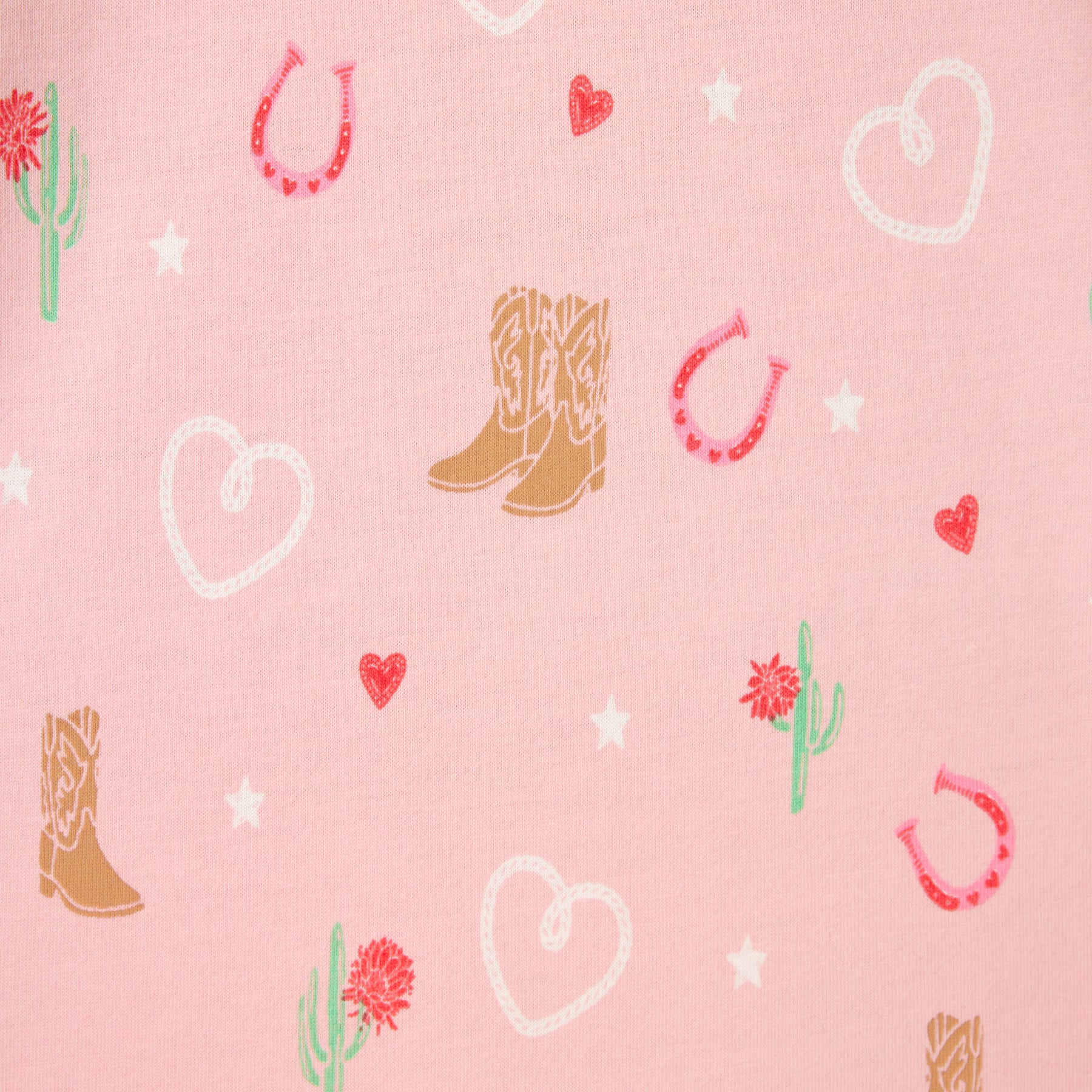 Fabric close-up of the pink pyjama print featuring hearts, horseshoes, boots, cacti, and star motifs.