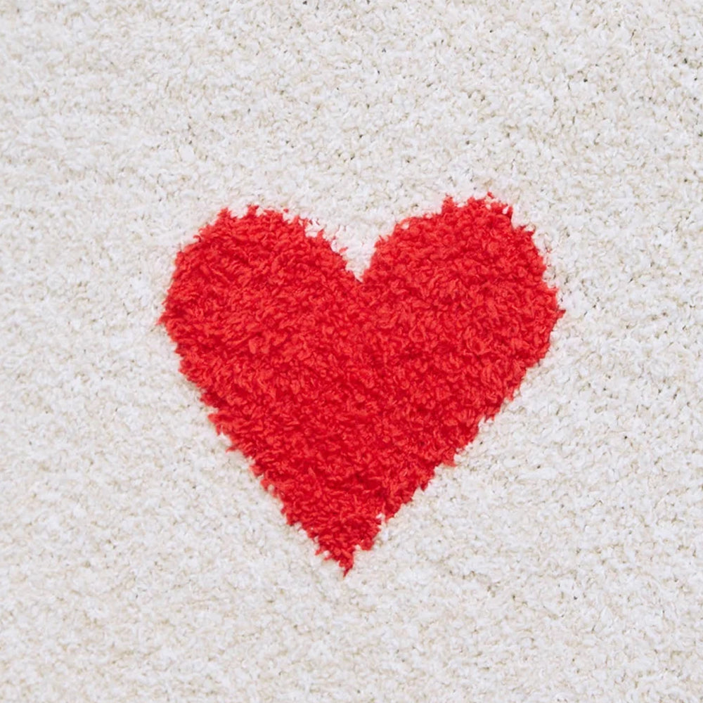 Close-up of soft, textured oat heather knit fabric featuring a bright red heart design.